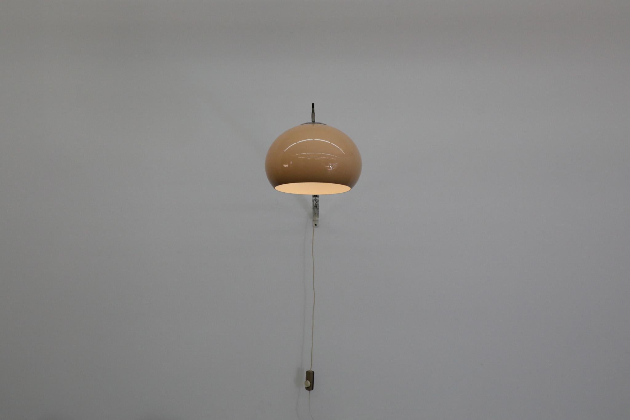 1970s chrome wall mounted adjustable arc lamp with beige plexi globe shade and dimmer switch. The arm extends by loosening the plexi and chrome knobs. Mounted height as shot is is 71” high. In original condition with visible wear consistent with its