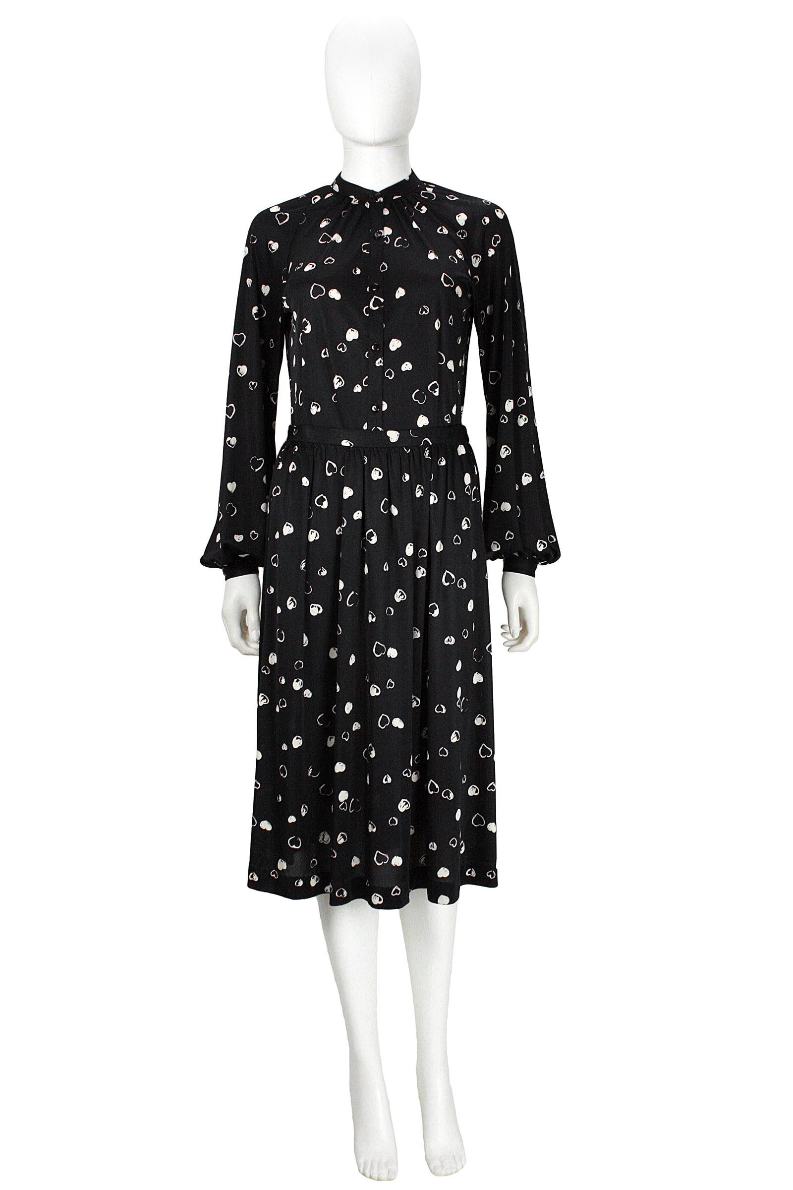 Halston button-down shirt and skirt
Black polyester with white hearts print 
Buttons closure on top
Hook and eye closure on skirt 
Tailored in Hong Kong 
Skirt waist is 27 inches
Skirt length is 28 inches 