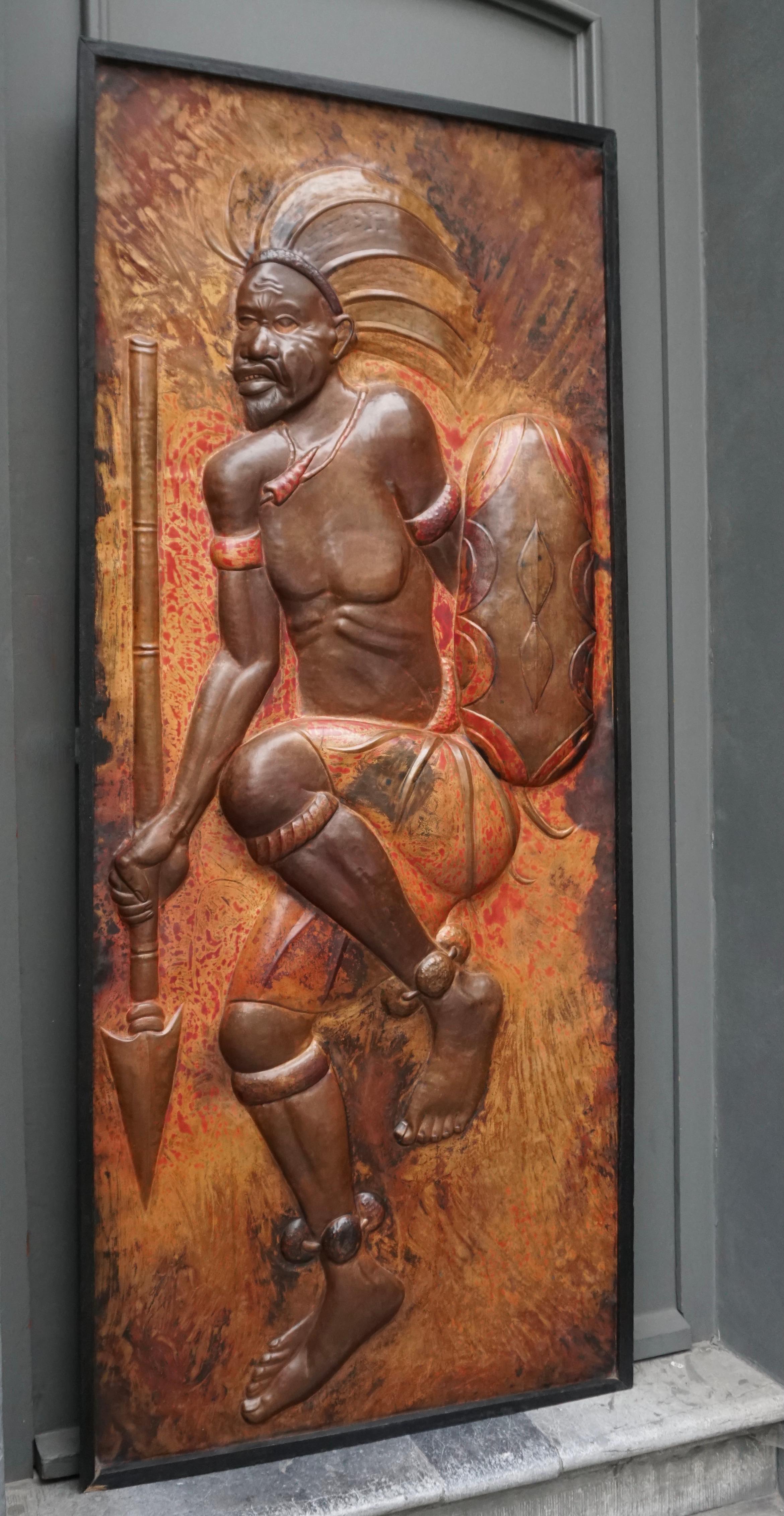 Rare et magnifique panneau de cuivre martelé grandeur nature représentant un guerrier africain dansant avec sa lance et son bouclier.

Panneau en cuivre forgé dans le style du célèbre artiste zaïrois Gabriel Kalumba Tshung Manu (1940-2019), qui a