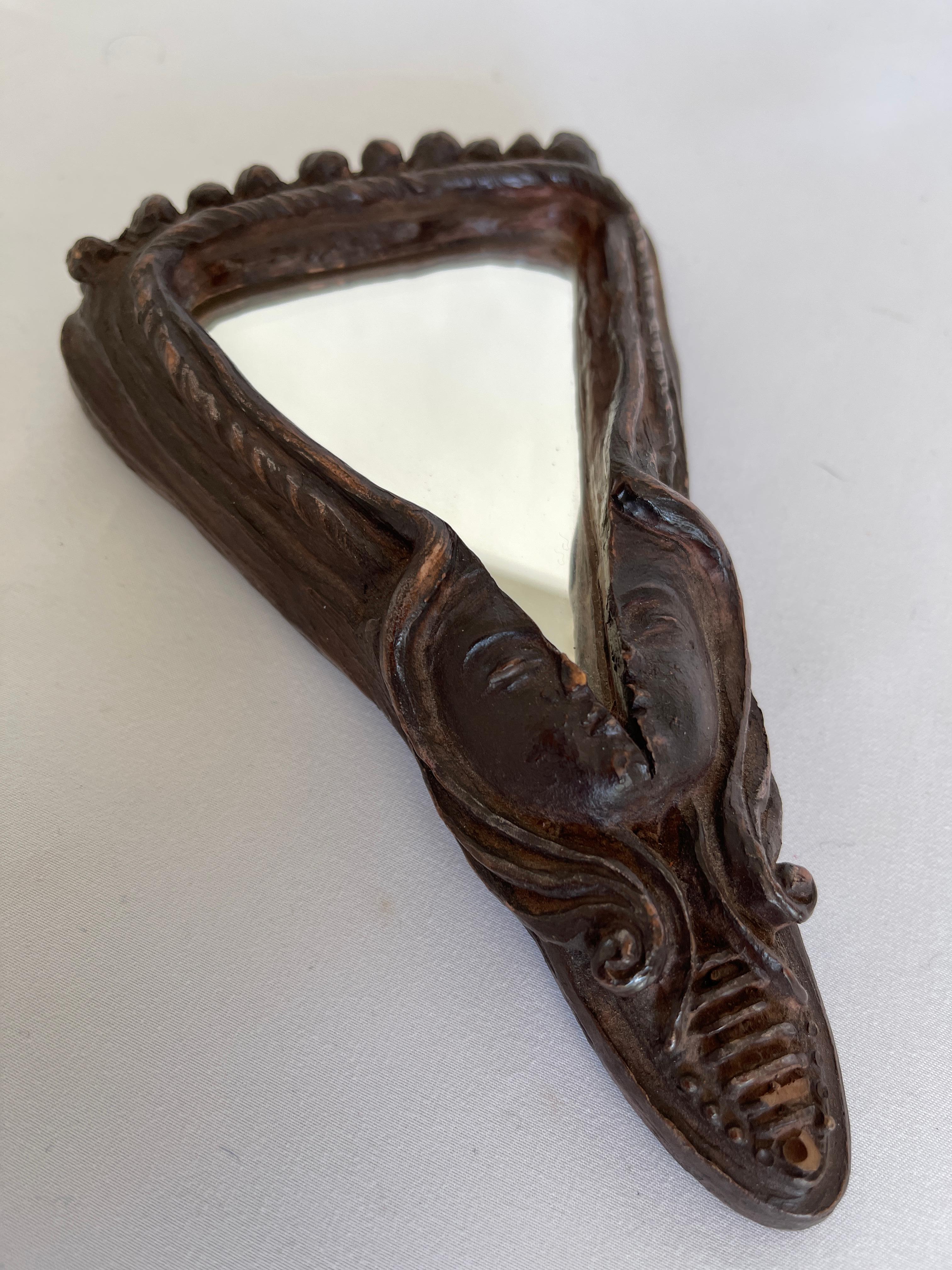 Hand carved face sculpture resin mirror hangs with wire loop at back.
USA, circa 1970's