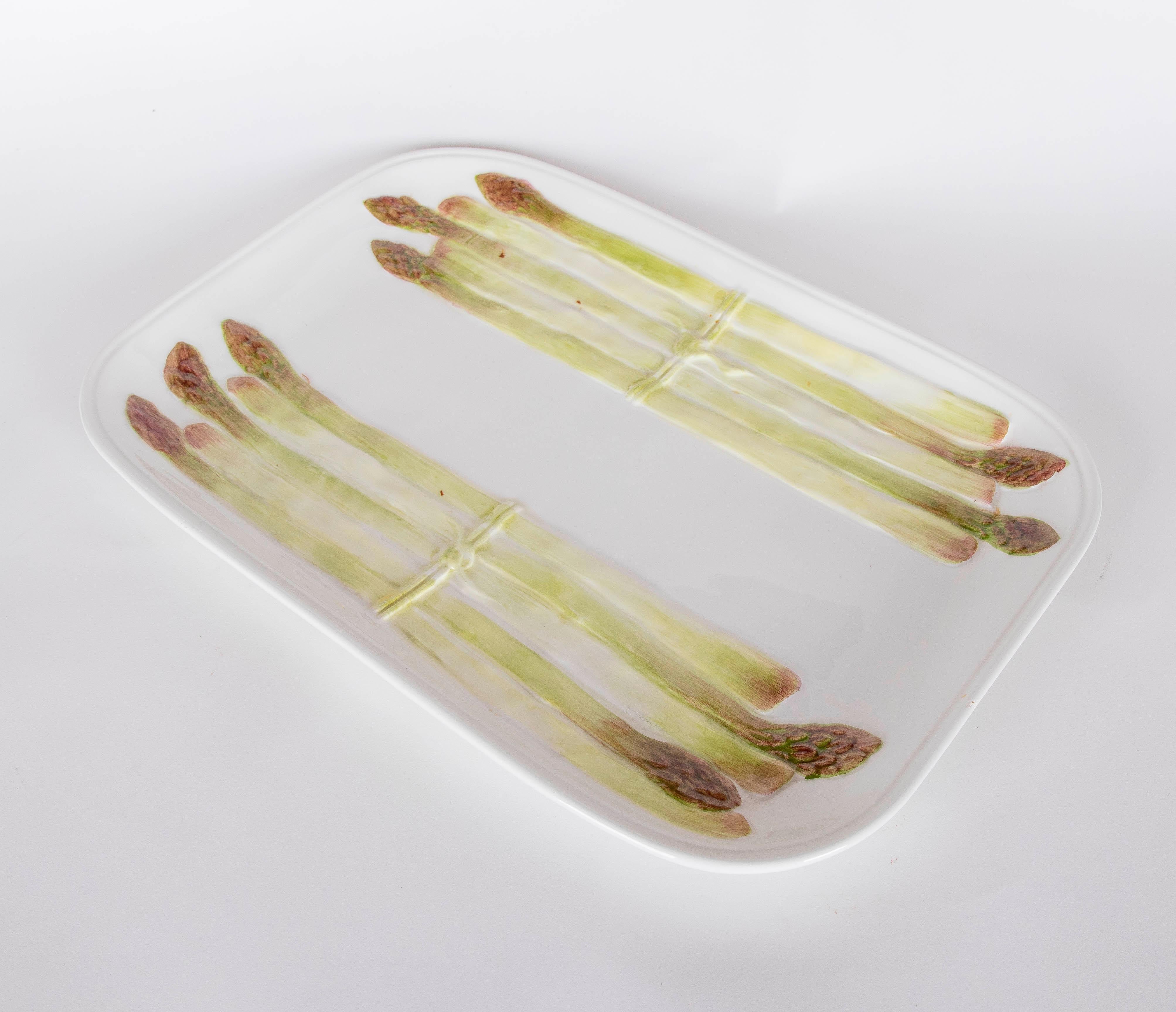 Bandeja rectangular de cerámica fabricada en Italia, decorada a mano con un motivo realista de espárragos en tonos verdes y violetas. La pieza destaca por su diseño minimalista y funcional, ideal para servir o como elemento decorativo en mesas y
