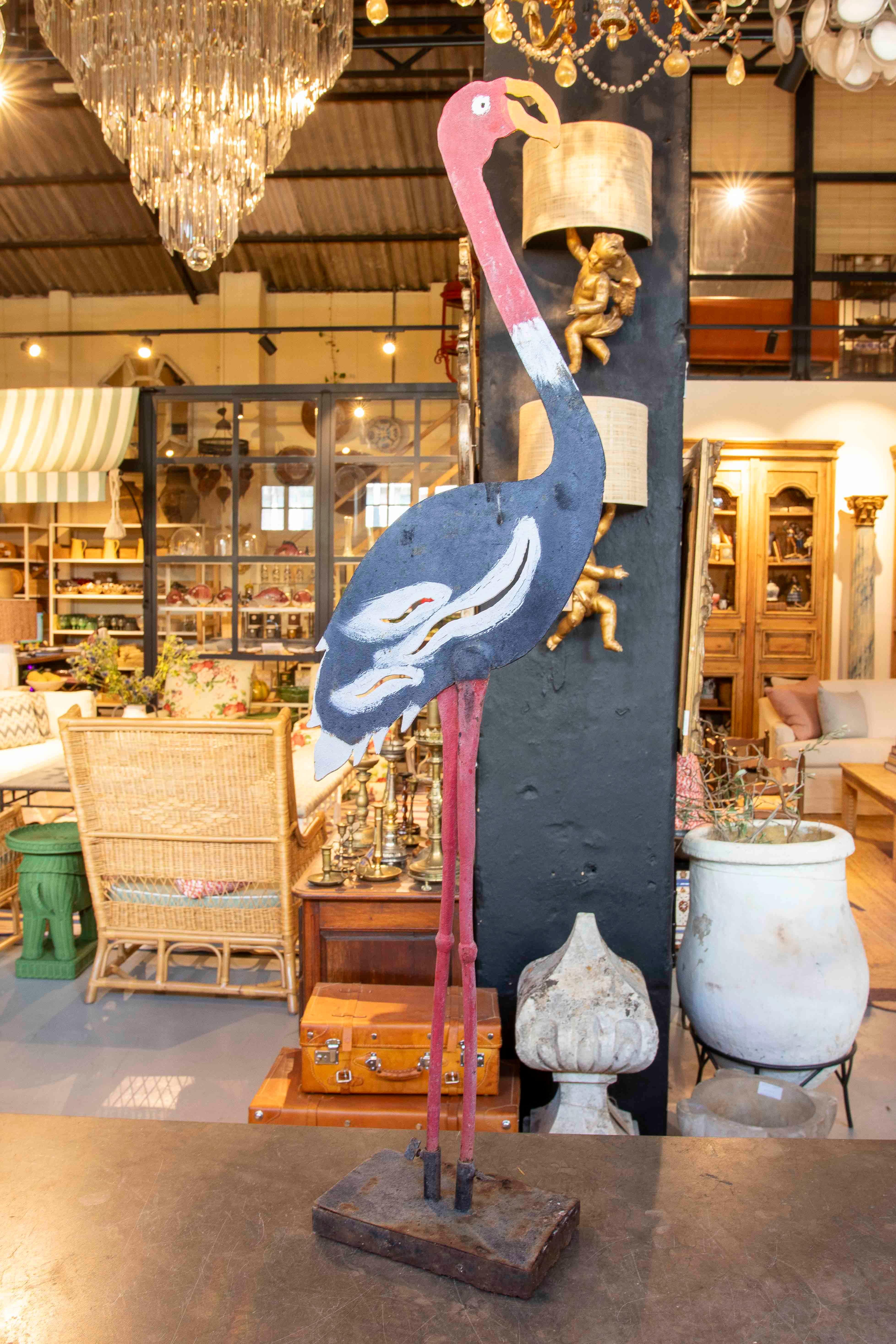 Sculpture décorative en fer représentant un flamant rose peint à la main, dont la peinture artisanale met en valeur les détails et les formes stylisées. Montée sur une base en métal, cette pièce allie un design rustique et artistique, idéal pour