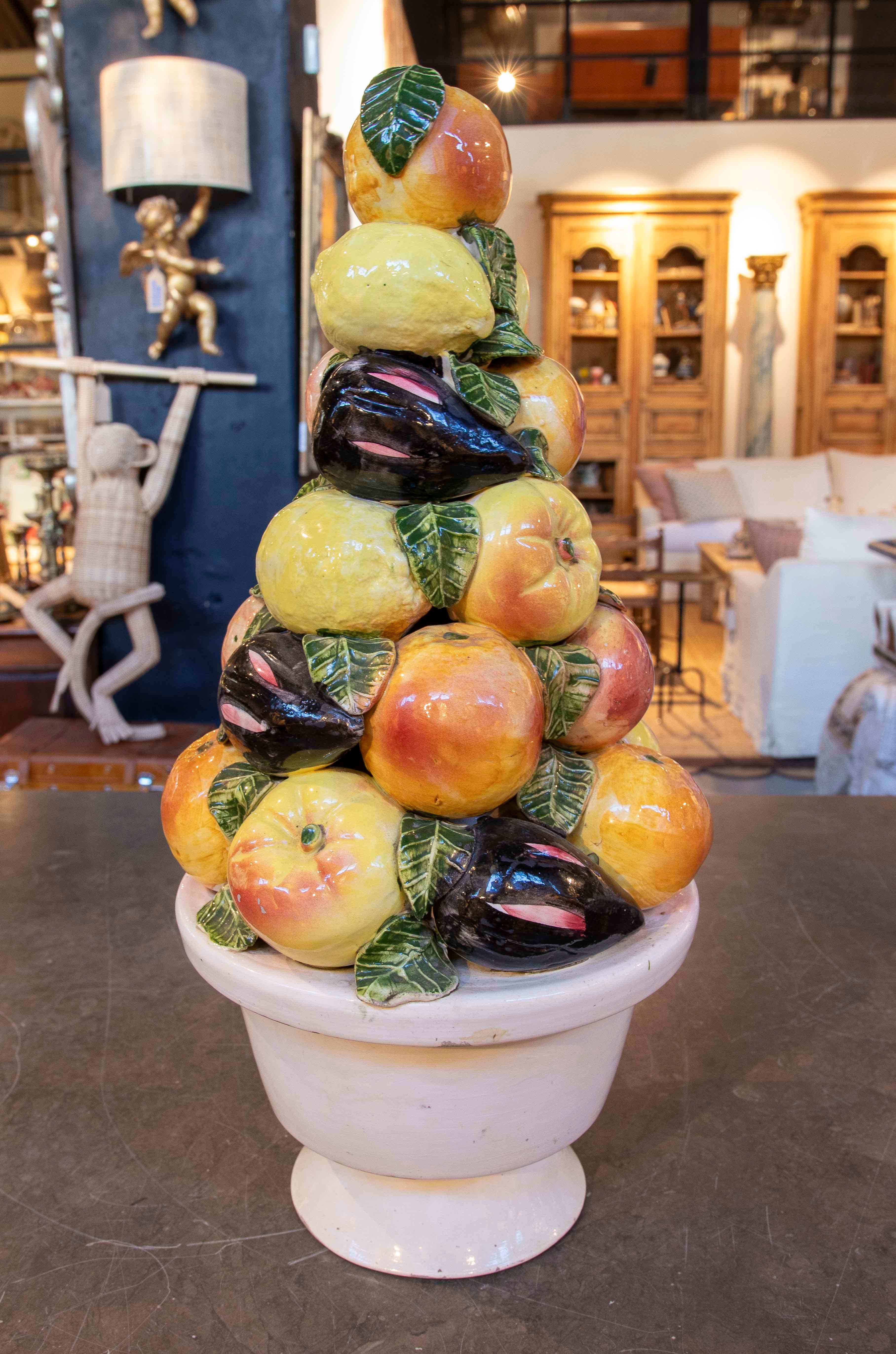 Decorative centerpiece crafted in glazed ceramic, depicting a colorful composition of fruit stacked in a classic planter. Each fruit is hand-painted with vibrant details and a glossy finish, highlighting its realistic and handcrafted appearance.