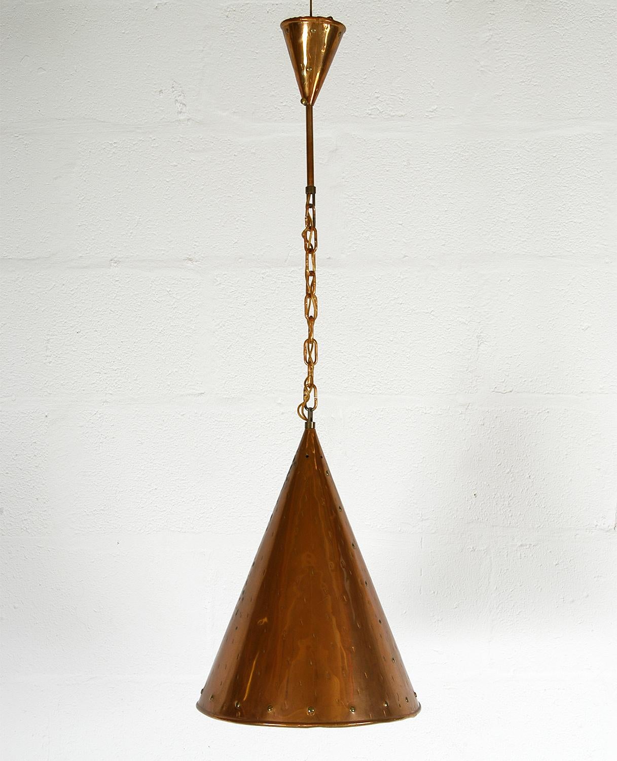 A lovely rustic Danish handmade conical copper ceiling pendant with brass rivet detail and a rolled bottom rim. The empty areas of copper have been decorated with a hammered detail. The pendant hangs from a copper chain with matching copper ceiling