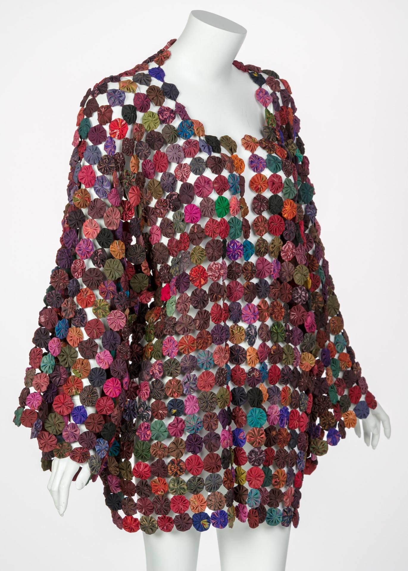 This technicolored, handstitched jacket is constructed of hundreds of circular rosettes or “yo-yos” through a needlework technique known as “yo-yo quilting” which derives its name from the yo-yo toy that was popularized in the United states in the