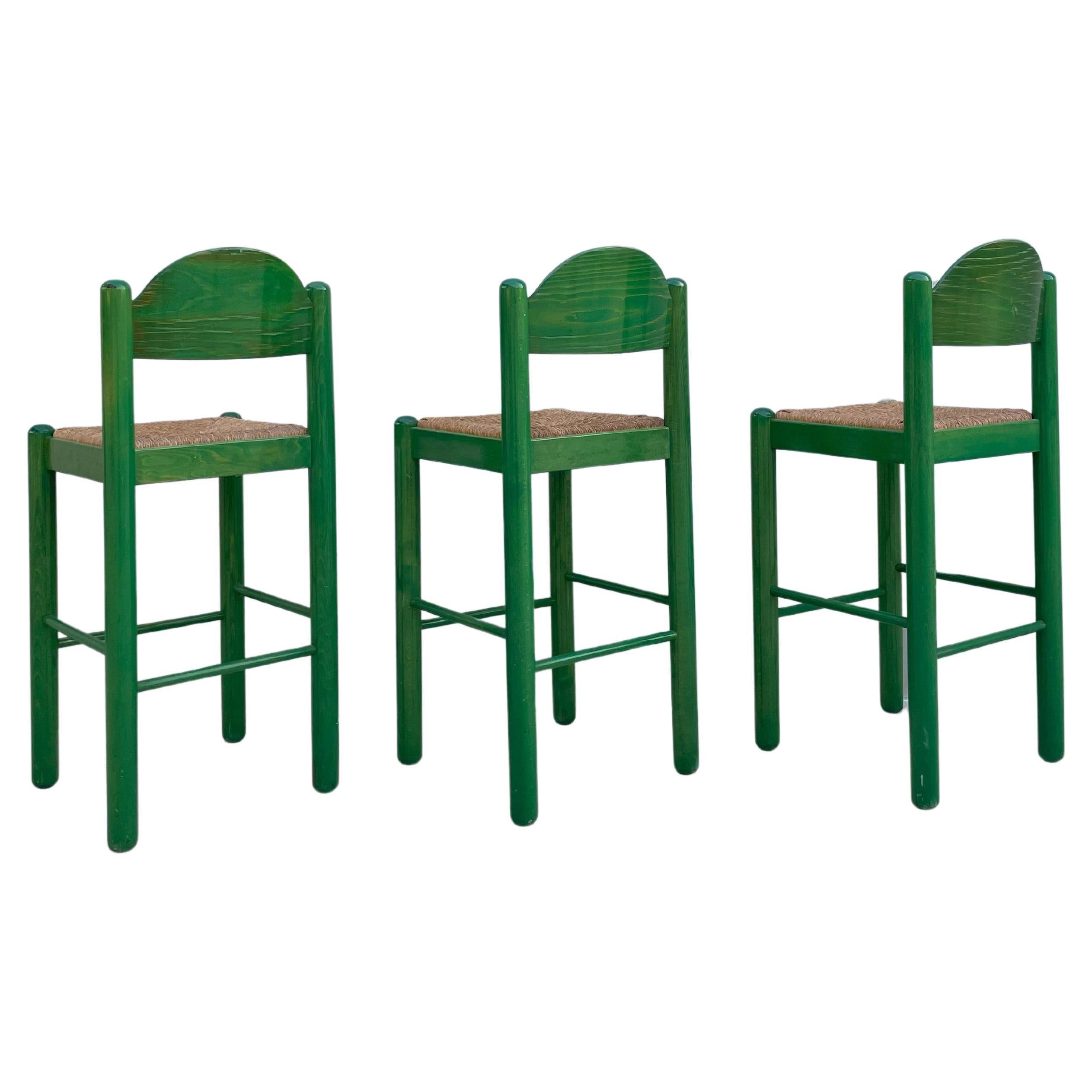 Set of 3 vintage Hank Lowenstein Padova Bar Stools. Original rush seats and green varnish. Rush seating is in excellent condition; some wear and fading to the varnish in different areas of the chairs. Lightly used, with light scratches, or minor
