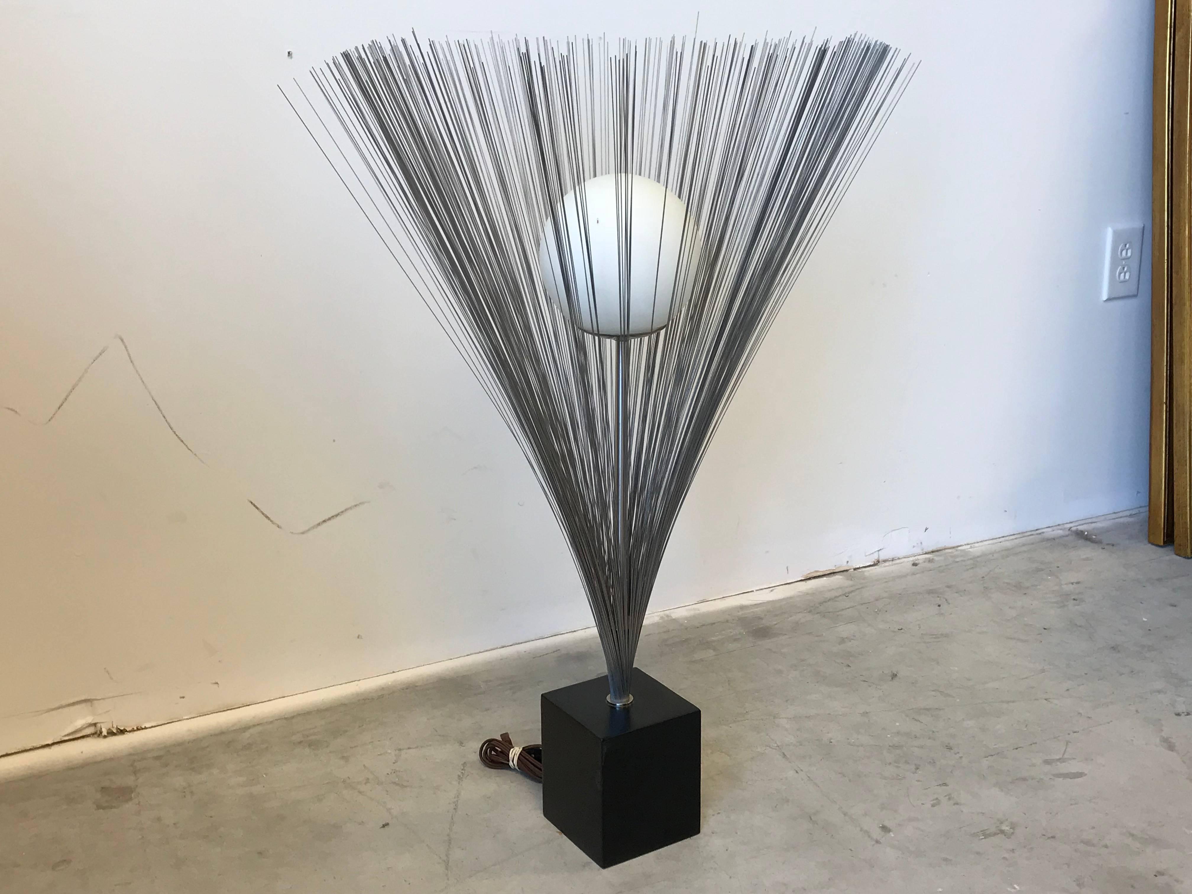 Listed is a mod and glam, 1970s Harry Bertoia style Laurel Lamp Co. metal spray lamp with glass orb. Based on the Harry Bertoia spray sculpture.