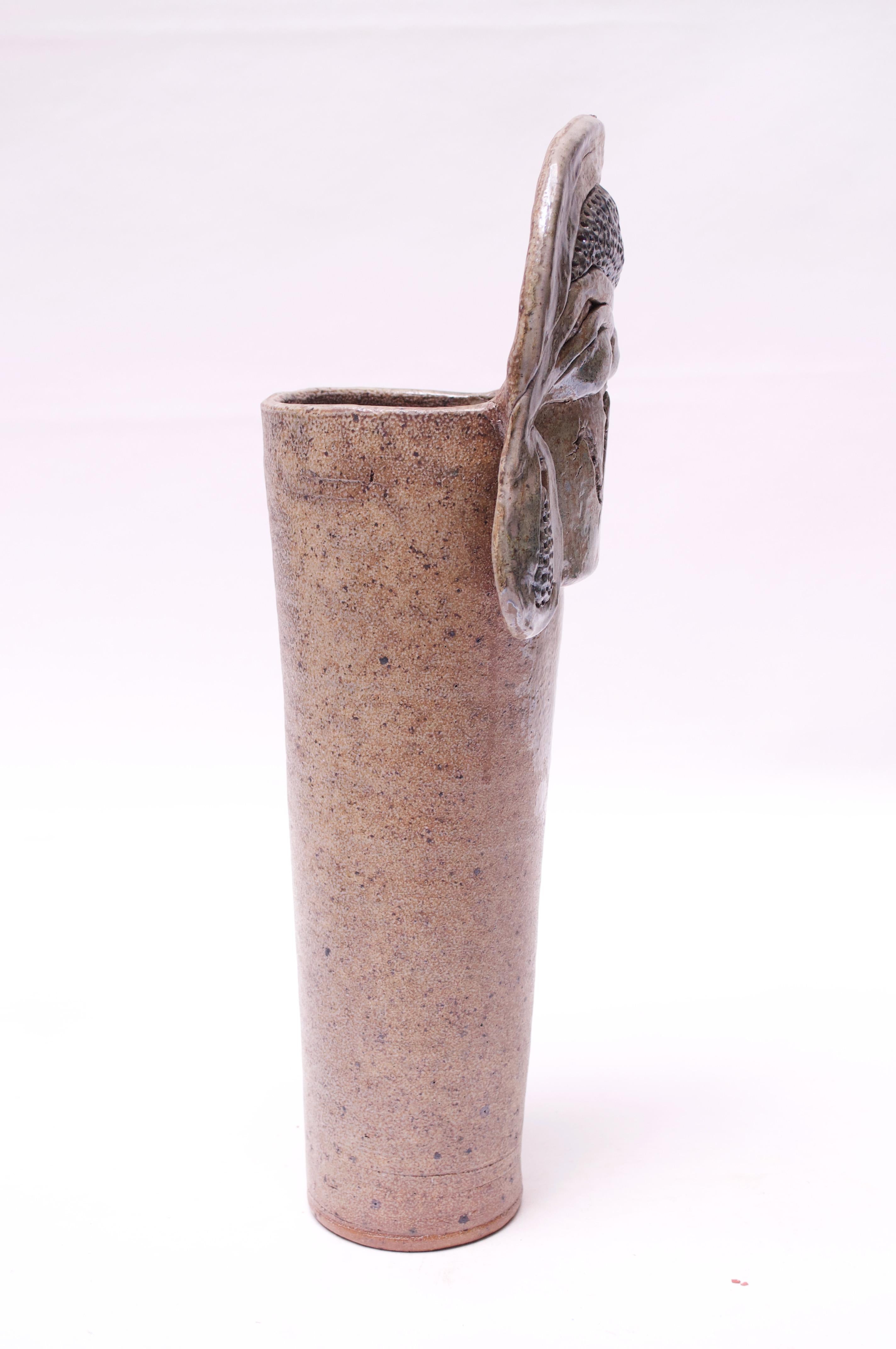 Striking and unique stoneware vase made in 1976 by ceramicist, Pollack. Interesting incorporation of textures and patterns - a matte-beige mottled surface with a slight metallic sheen and applied metallic fragments. Signed 
