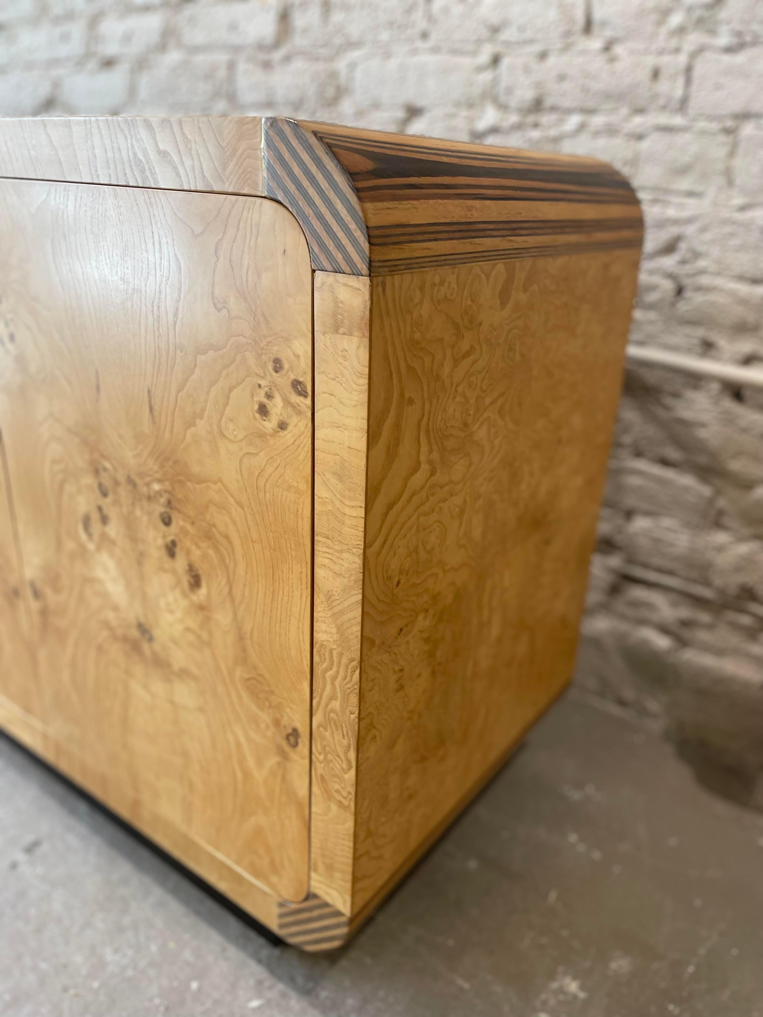Fully restored burl wood Henredon scene two credenza buffet in olive ash burl with zebra wood inflated corners. Item sits on a plinth base for greats stability. Item is opens to one shelf and one open area. Item is structurally sound and fully