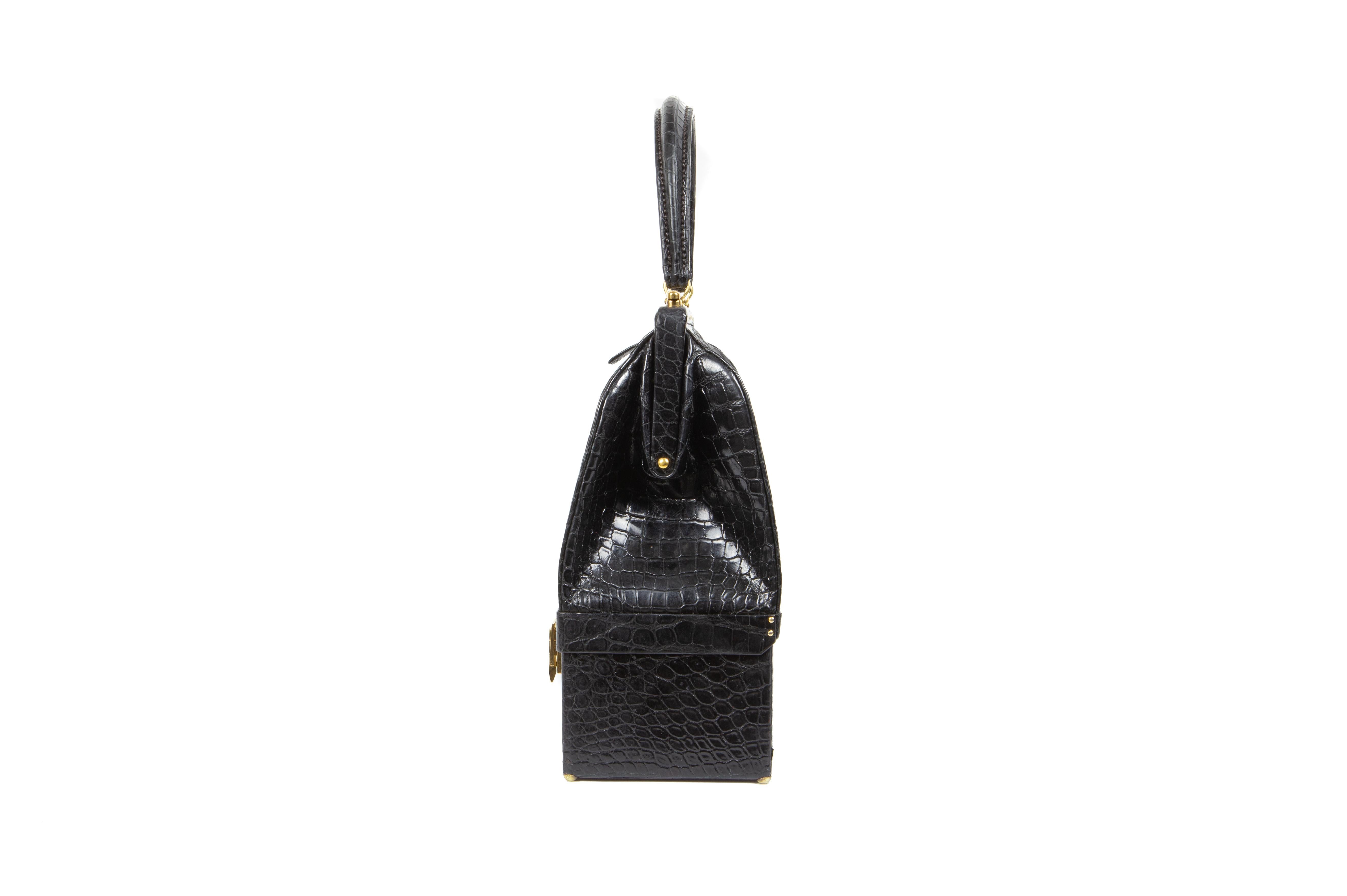 An understated, rare and highly collectable early 1970s Hermes black porosus crocodile Sac Malette with self-piping, comprising of one upper compartment with one gusseted tab patch pocket and one further pocket, both with press-stud closure, lined