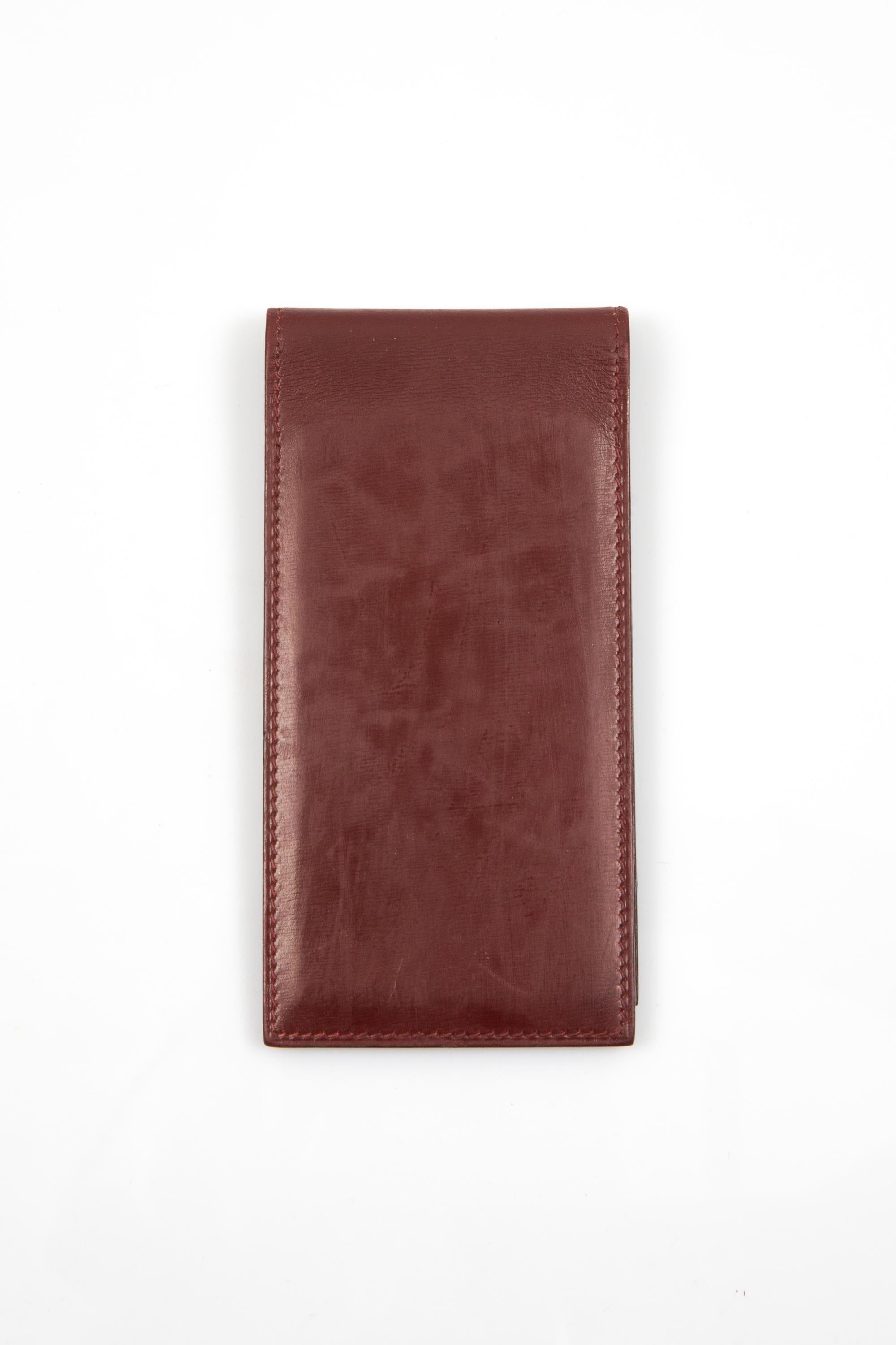 Portablocco Hermes in pelle bordeaux con forma rettangolare pieghevole, tasca interna e firma Hermes all'interno.
Circa anni '70 100% pelle di scatola
In buone condizioni vintage. Prodotto in Francia. 
Lunghezza: 6,5 cm.
Altezza: 15,1 pollici (13