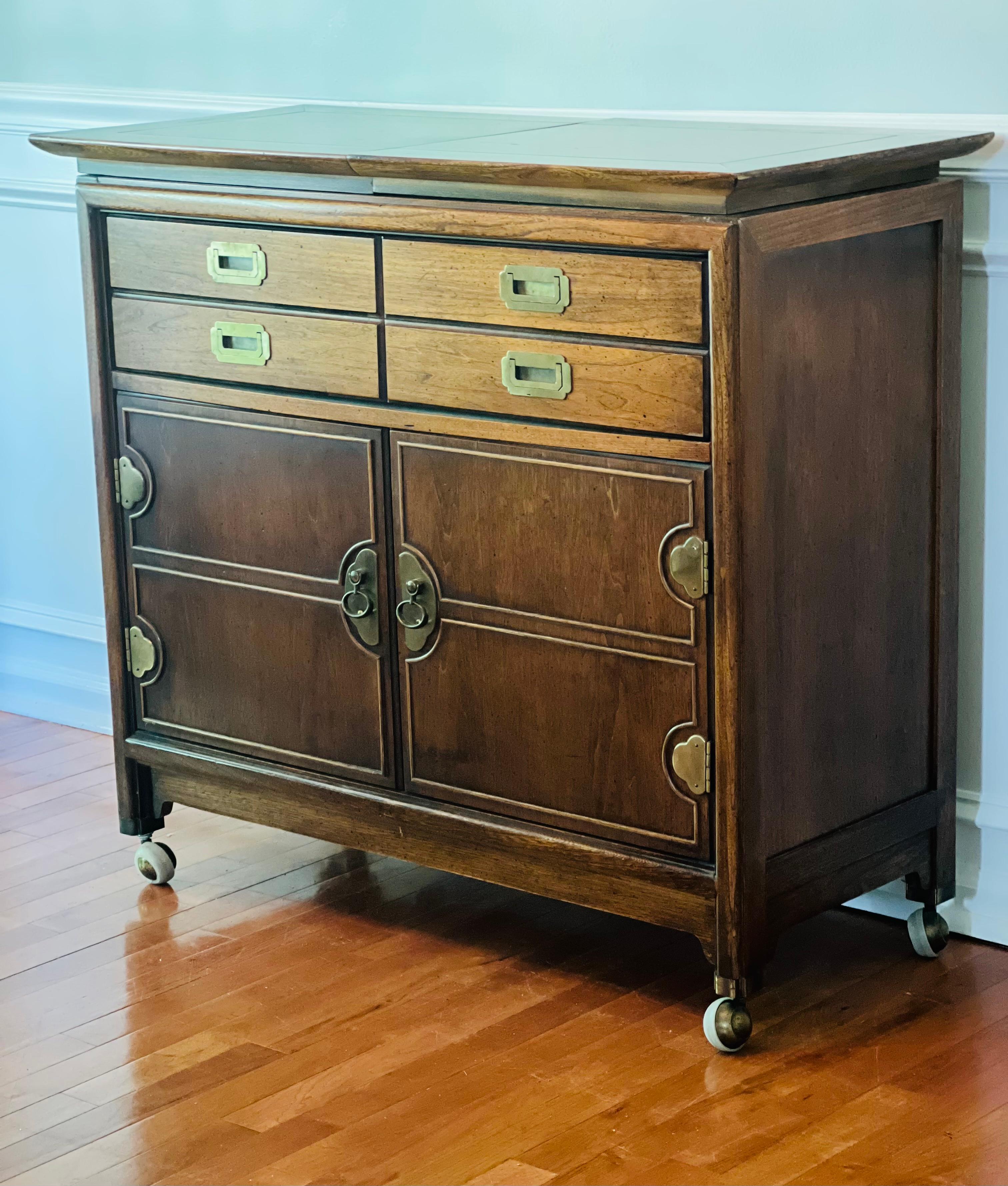 Beautiful and efficiently designed fruitwood server/sideboard on caster wheels. Lots of storage and wheels maneuver with ease. Features one divided drawer with double hardware and a lower cabinet with two shelves. The top opens up to provide extra