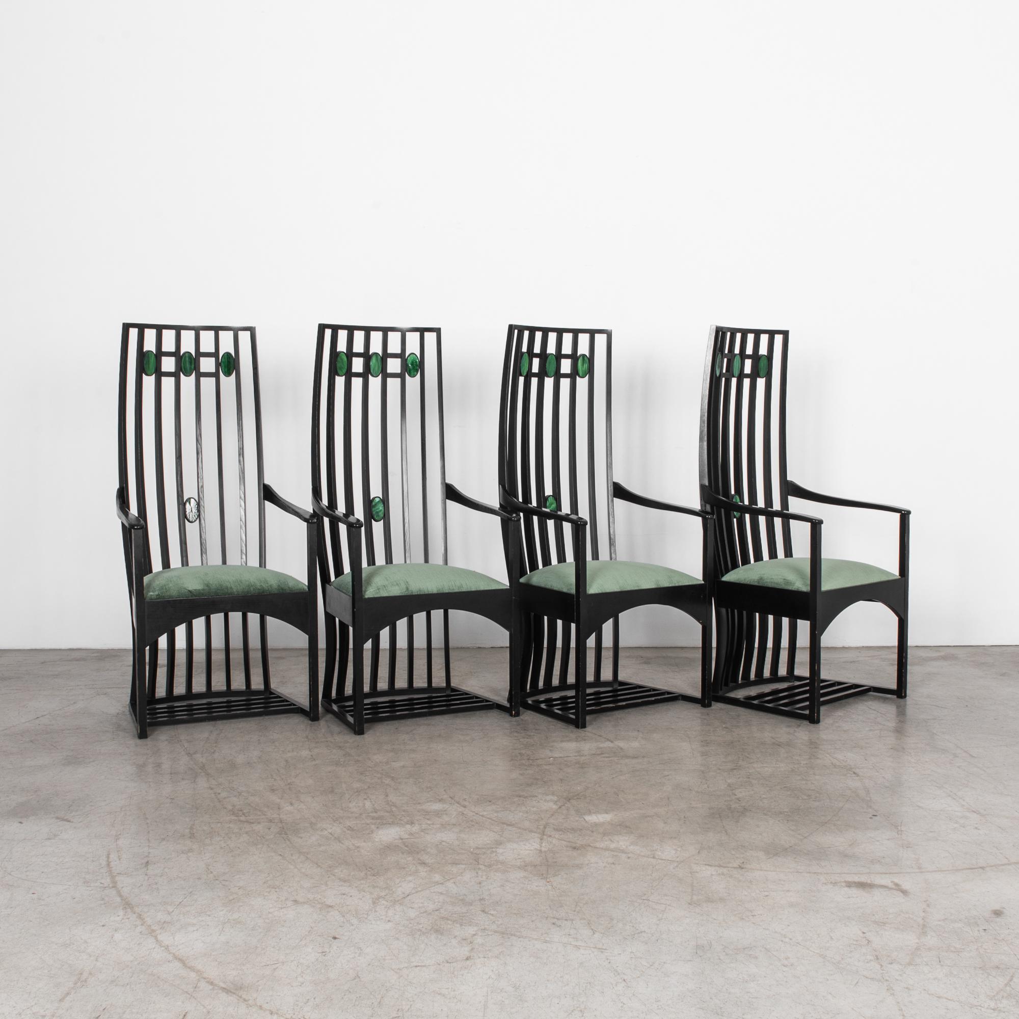 Attributed to Scottish architect Charles Rennie Mackintosh. This set of 4 armchairs are solidly constructed from European oak, with inset agate stones, and updated green velvet upholstery. Bold organic structure illustrates the linearity and