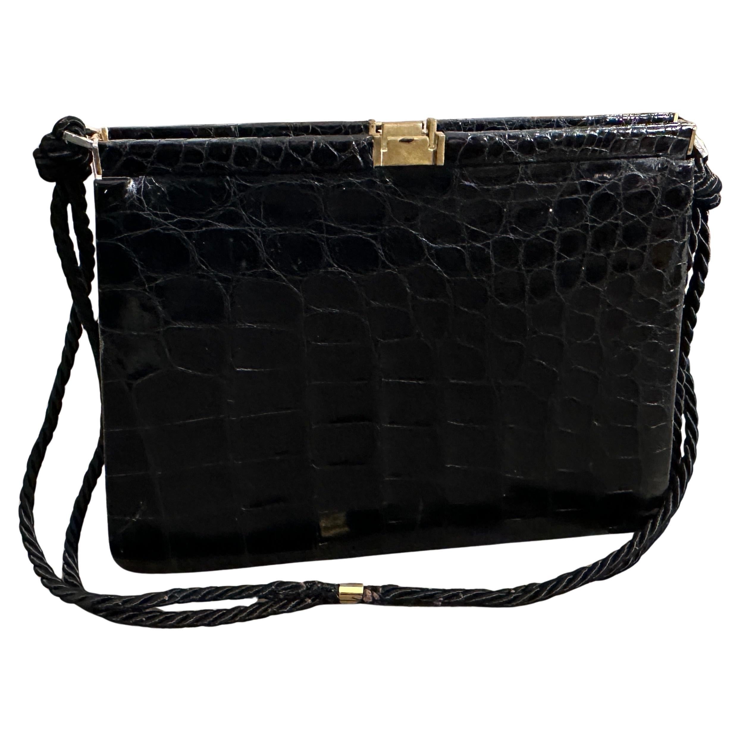 L'articolo è una borsa a tracolla vintage in pelle nera con caratteristiche distintive che si allineano agli accessori italiani di alta qualità degli anni Settanta. L'esterno della borsa è realizzato in pelle nera con una finitura altamente lucida e
