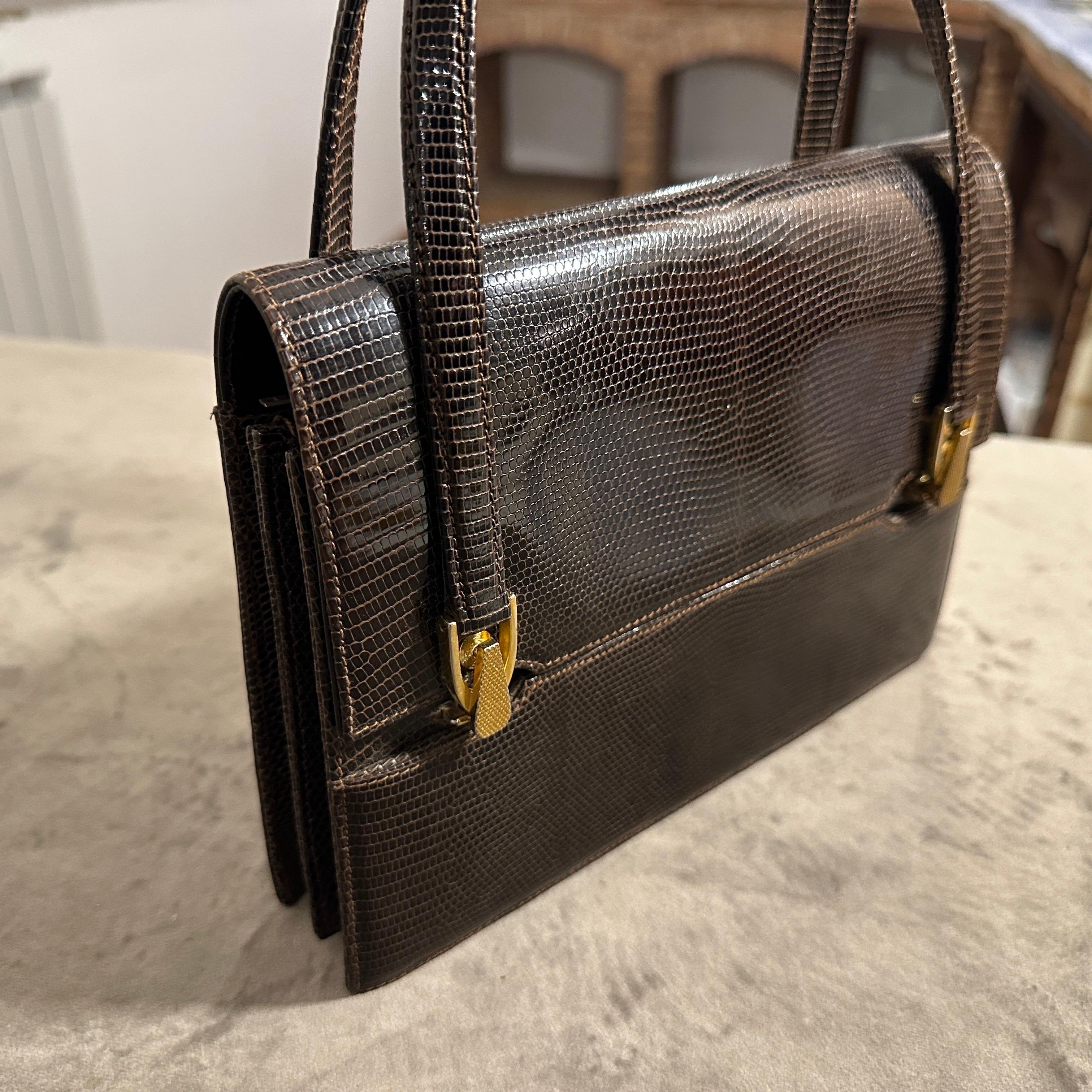 Este exquisito bolso italiano vintage de alta calidad de los años 70 es un testimonio de la artesanía perdurable y el estilo refinado de su época. Esta sofisticada pieza está expertamente elaborada en cuero marrón, con una característica textura de