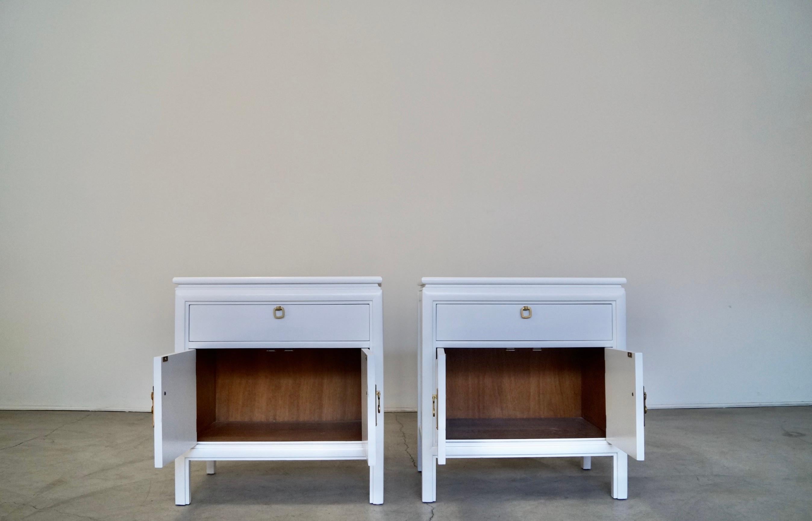 Pair of vintage Mid-Century Modern night stands for sale. Have a Hollywood Regency design, and are from the 1960's. They have been professionally refinished in white, and have the original solid brass pulls and knobs that have been polished. They