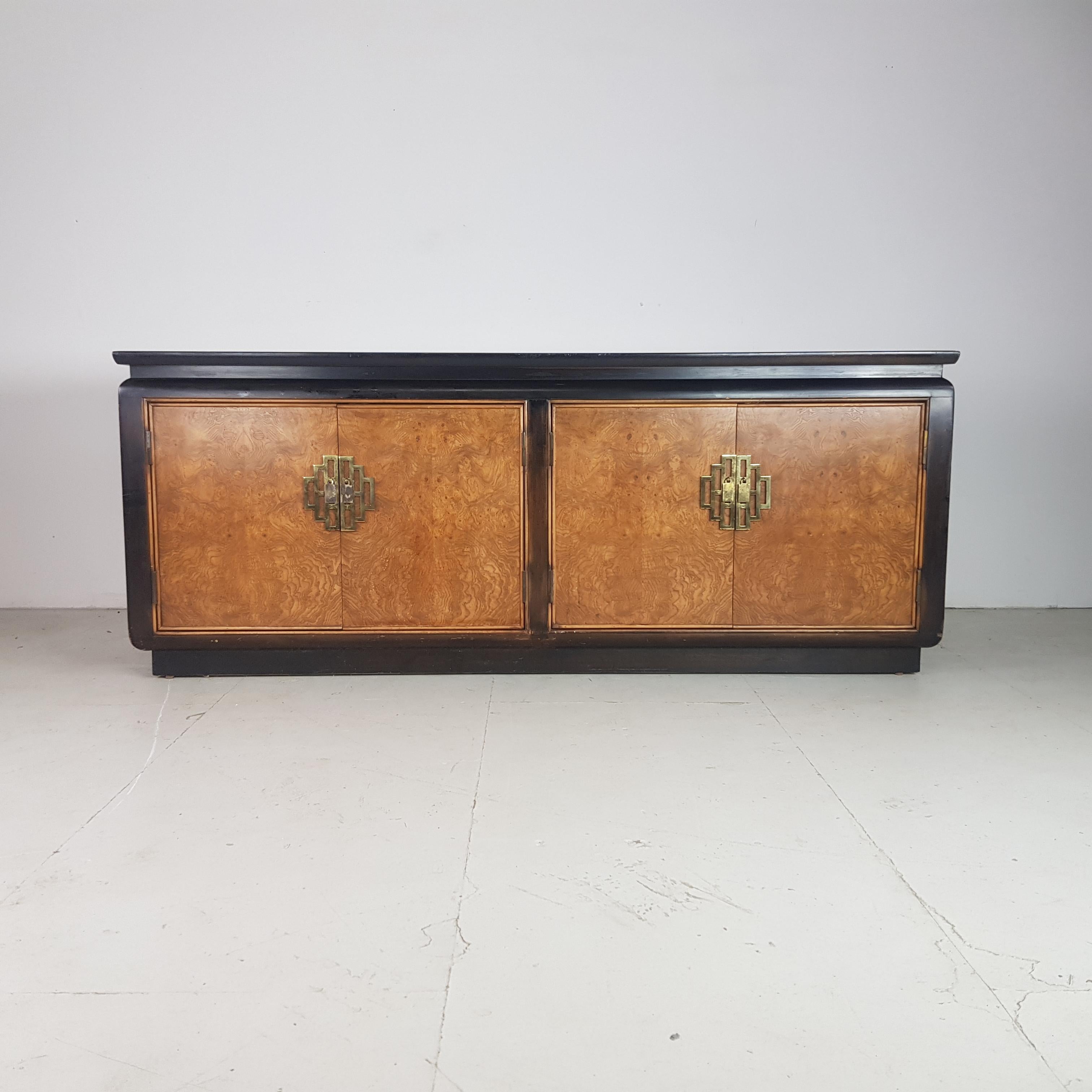 Very glamorous Hollywood Regency chinoiserie sideboard made by Century Furniture and purchased from Harrods in the 1970s. Made of black lacquer and burl wood with brass handles.

In vintage condition. Two of the internal drawers are missing but