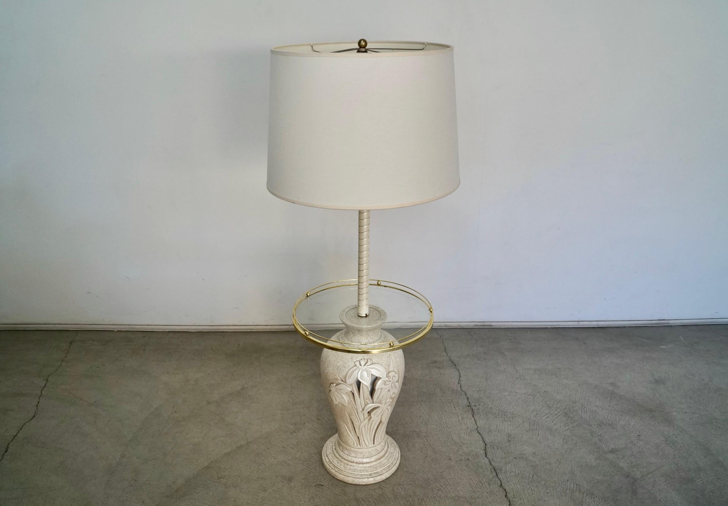 Vintage 1970’s Hollywood Regency floor lamp with attached side table for sale. In incredible condition, and very beautiful. Made of many different materials. Has a ceramic base with a glass end table and brass tray trim, and a metal pole with a