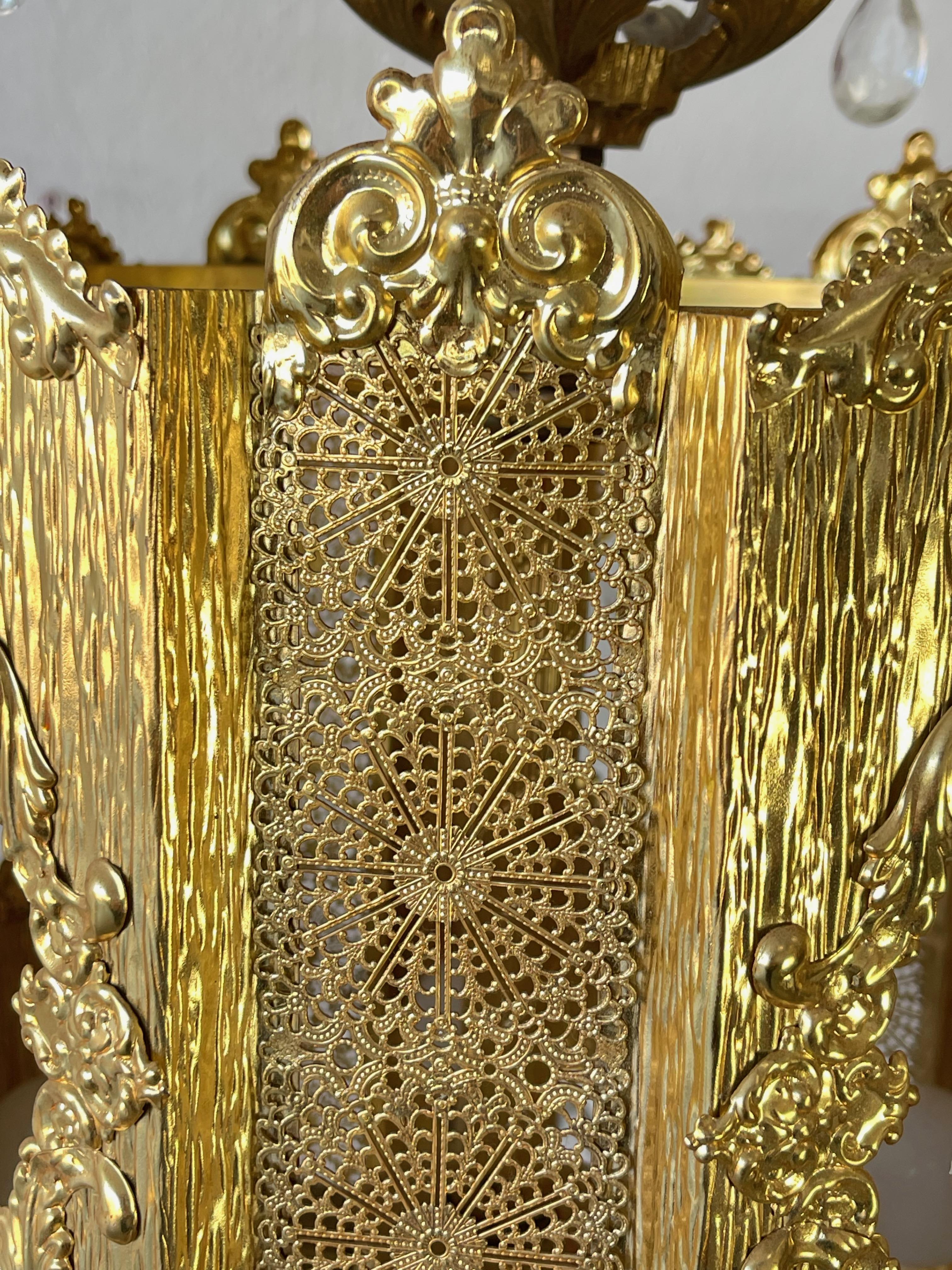 This is a really exquisite antique Hollywood Regency/Brass Filigree lantern style swag chandelier.The Brass work is very nice with high quality construction. The beautiful brass framework has lovely filigree work in the top and bottom. Sparkling