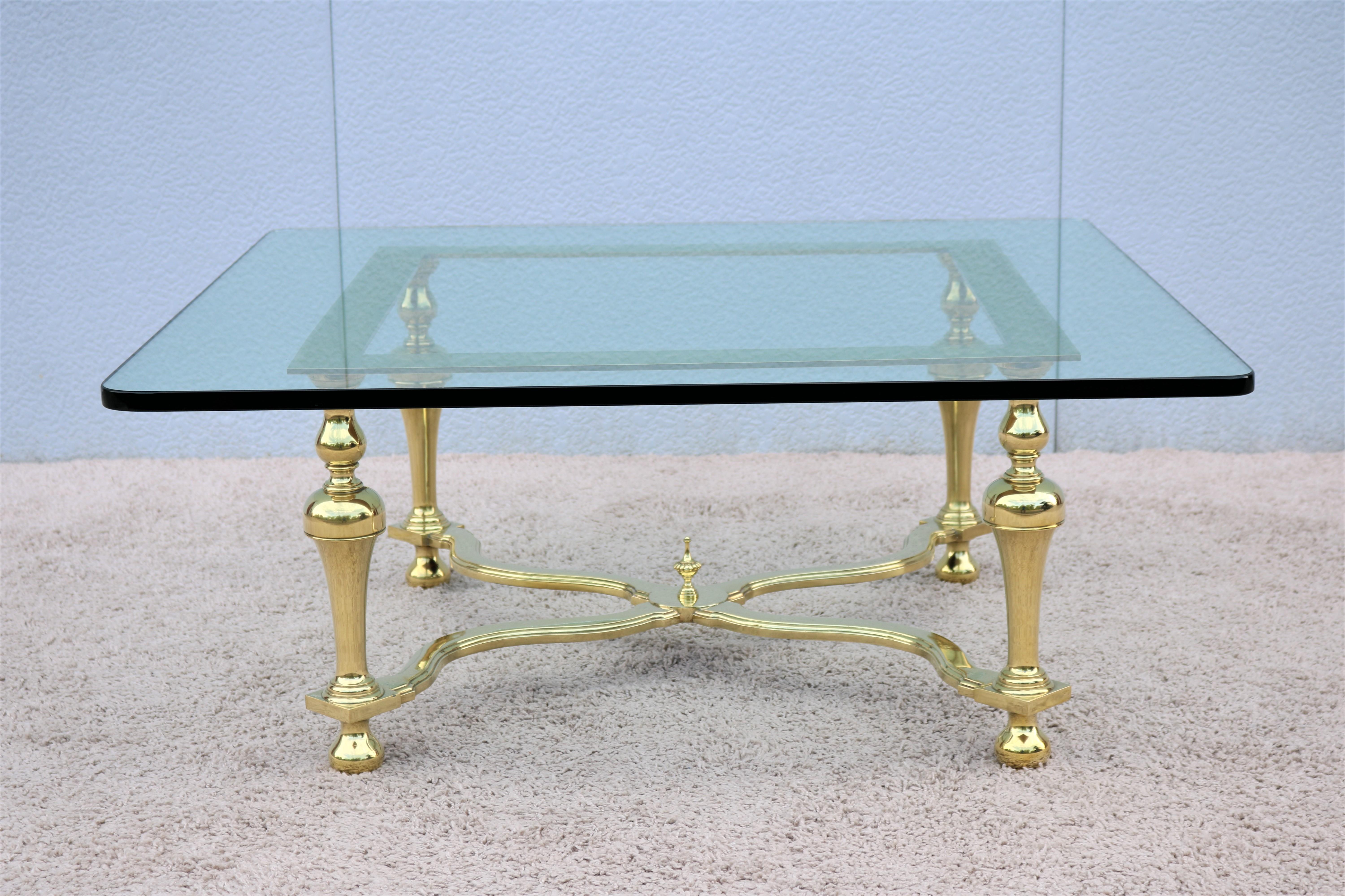 Stunning and elegant Maison Jansen style Hollywood Regency brass and glass square coffee table, features brass trumpet shaped legs and cross stretcher with a center ball finial, beautiful brass details make this table attractive center piece for