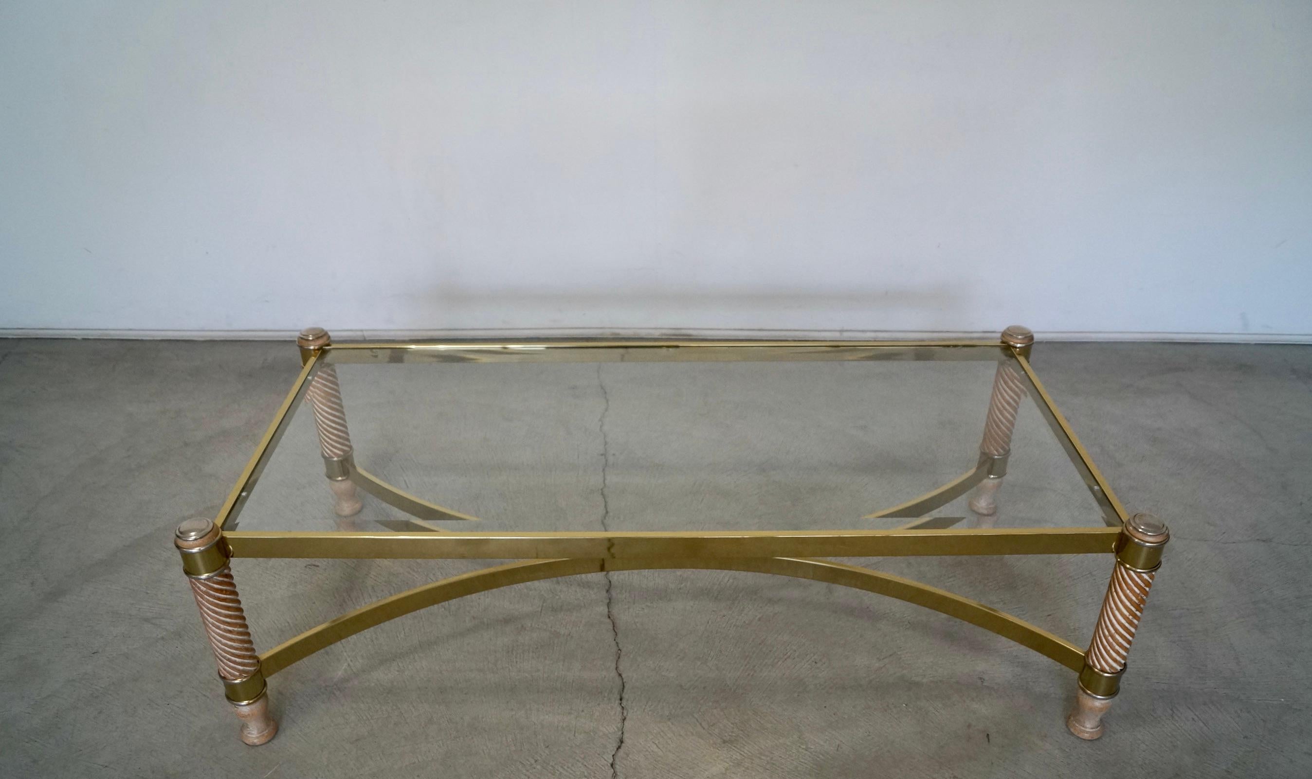 Vintage Hollywood Regency glass, brass, and wood coffee table for sale. It’s in amazing condition, and is very beautiful. It has a beveled glass insert in excellent condition with no chips or cracks. The brass is in incredible condition. It has four