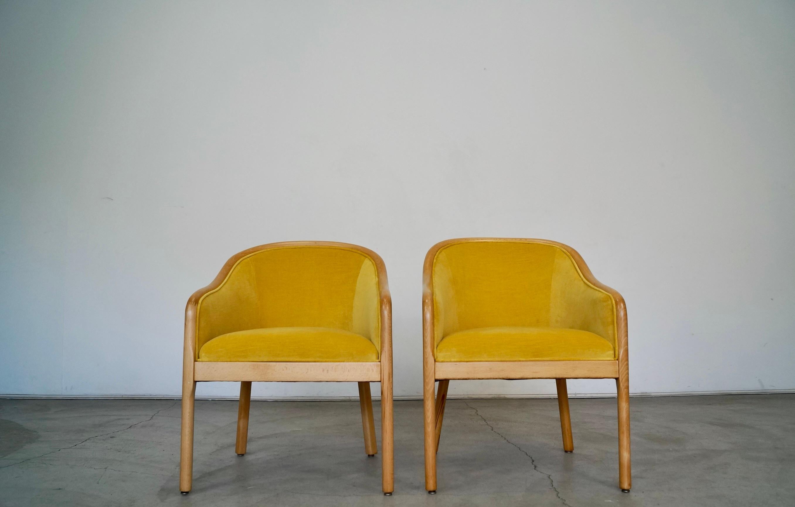 Pair of vintage 1970s arm chairs for sale. They have been professionally restored. They have been refinished in a natural beech finish, and reupholstered in new velvet and foam. The velvet is a gold yellow tone and goes beautifully with the natural