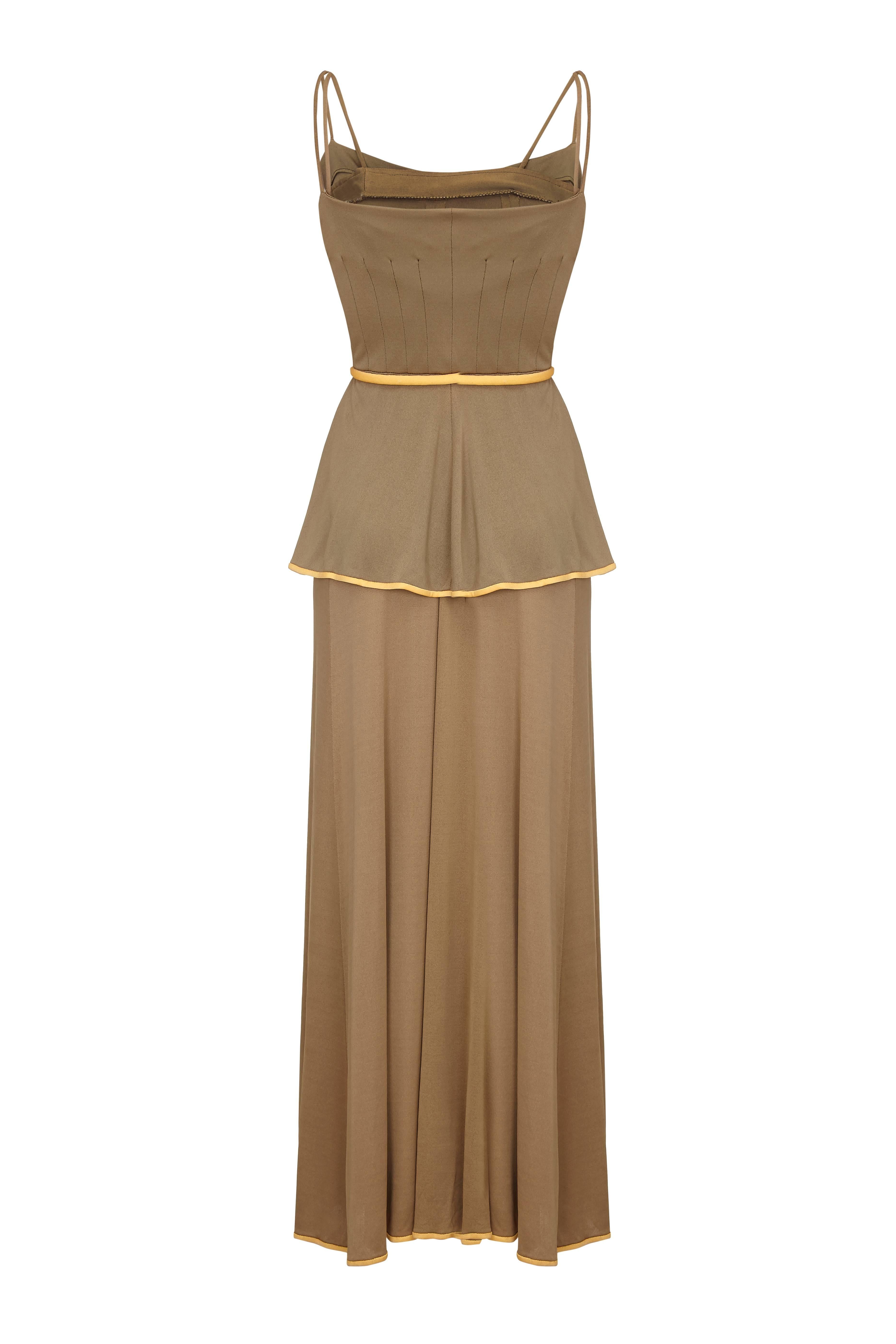 This charming  1970s olive toned silk jersey peasant style 2 piece is by American label Horiko for Saks 5th Avenue.  It is comprised of a floor length maxi skirt and strappy peasant vest with a pretty peplum waist.  
Both pieces feature piped seams