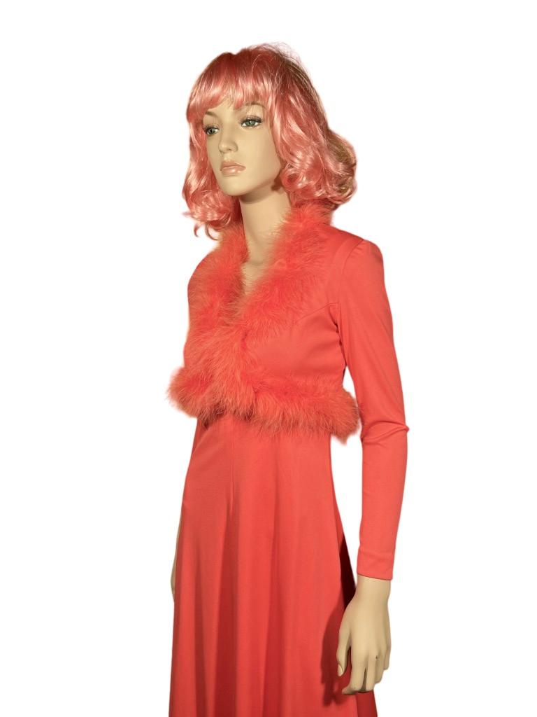 Here we have a 1970’s bright salmony pink nylon square-neck sleeveless floor-length polyester maxi dress with a darling matching marabou feather button up bolero jacket. The fabric is so vibrant it’s almost fluorescent. This piece was designed by