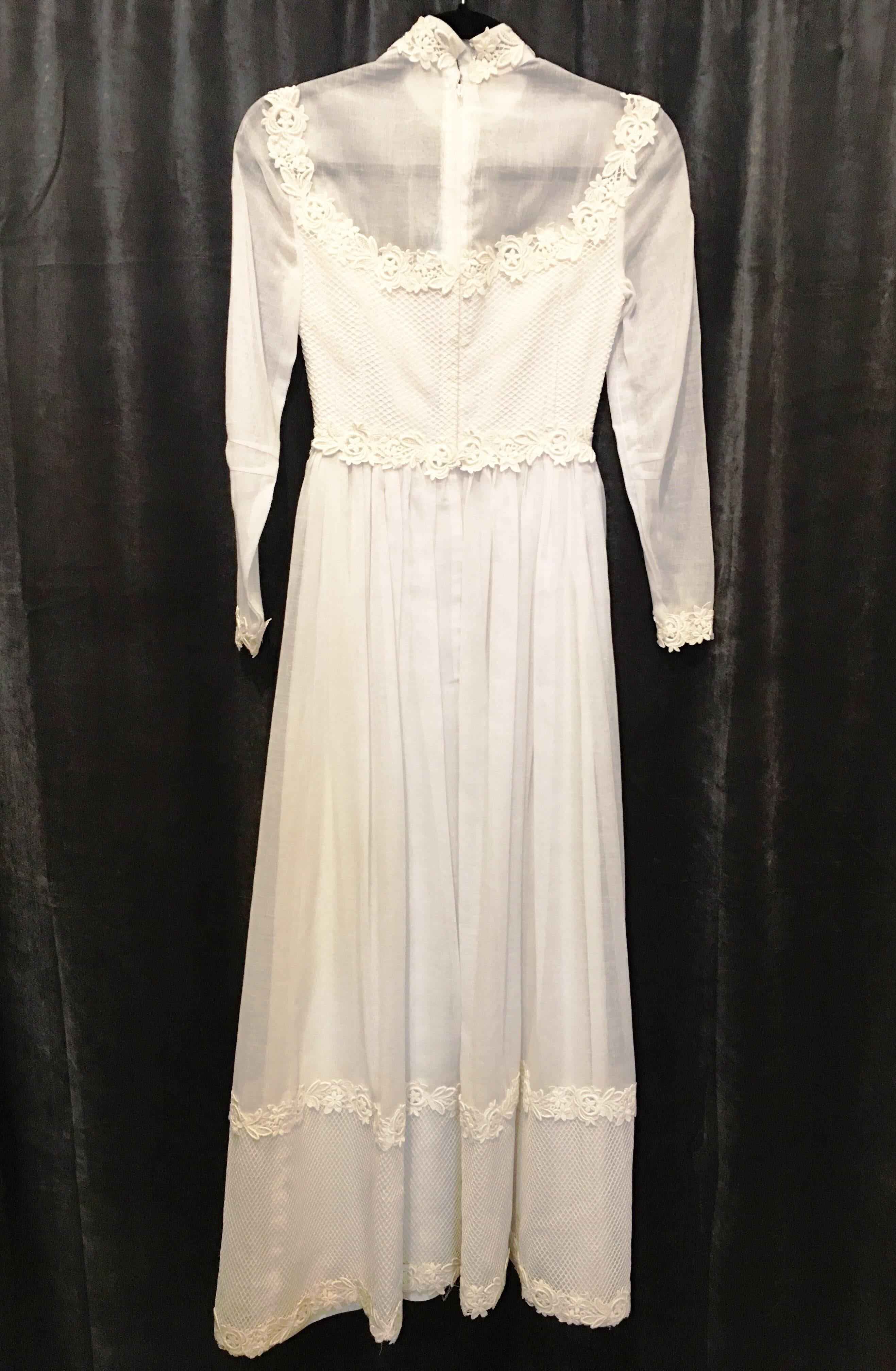 Linen wedding dress with lace trim and netting at hem and bodice. High collar with floral lace and floral lace at cuffs, as well. Bodice is sheer at arms and above bust. Dress zips halfway up the back and has two hook and eye closures at back of