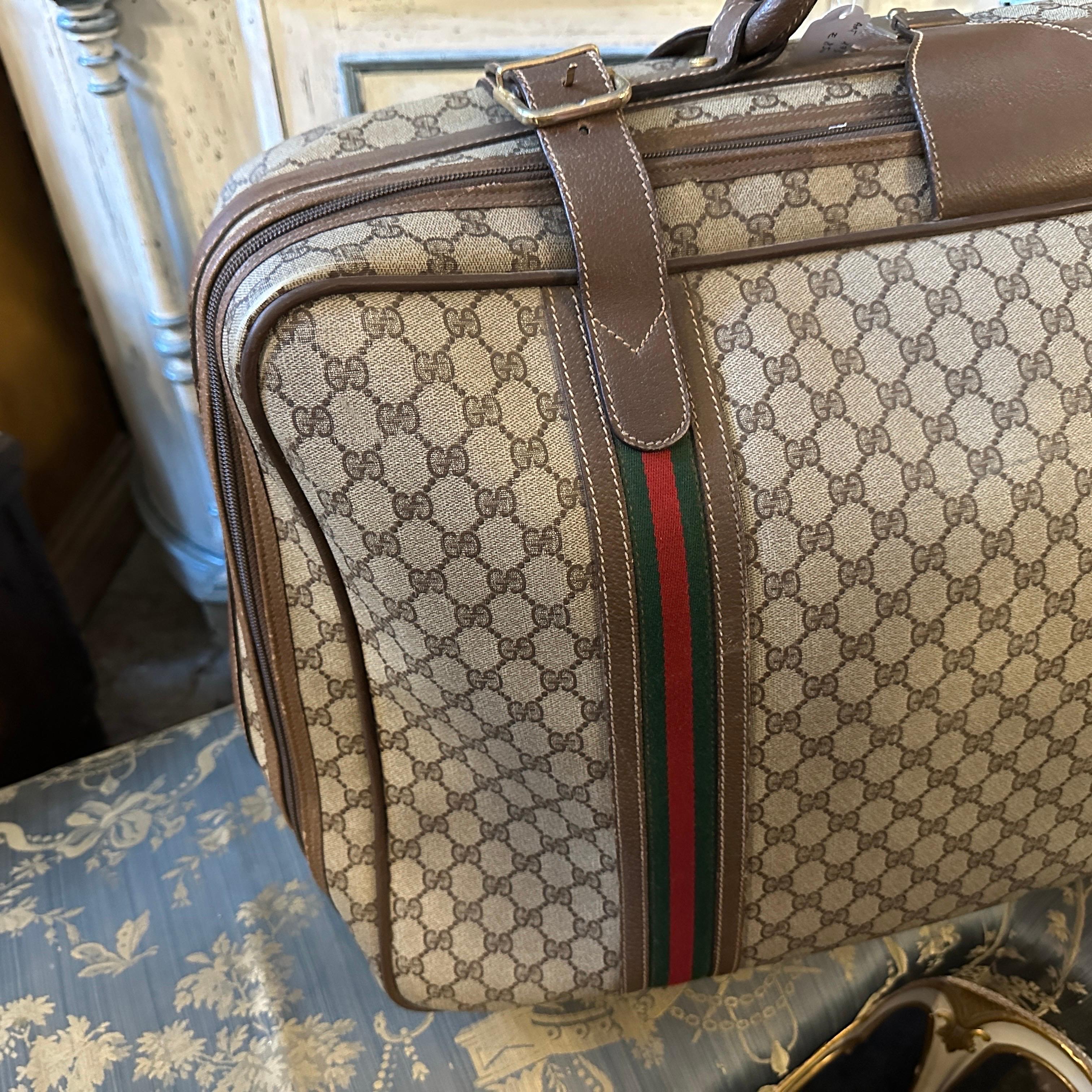 Travel in timeless style with this authentic and iconic vintage Gucci suitcase from the 1970s. This piece is a true collector's item, representing an era of glamorous jet-setting and classic Italian design.
The suitcase is made from the signature GG