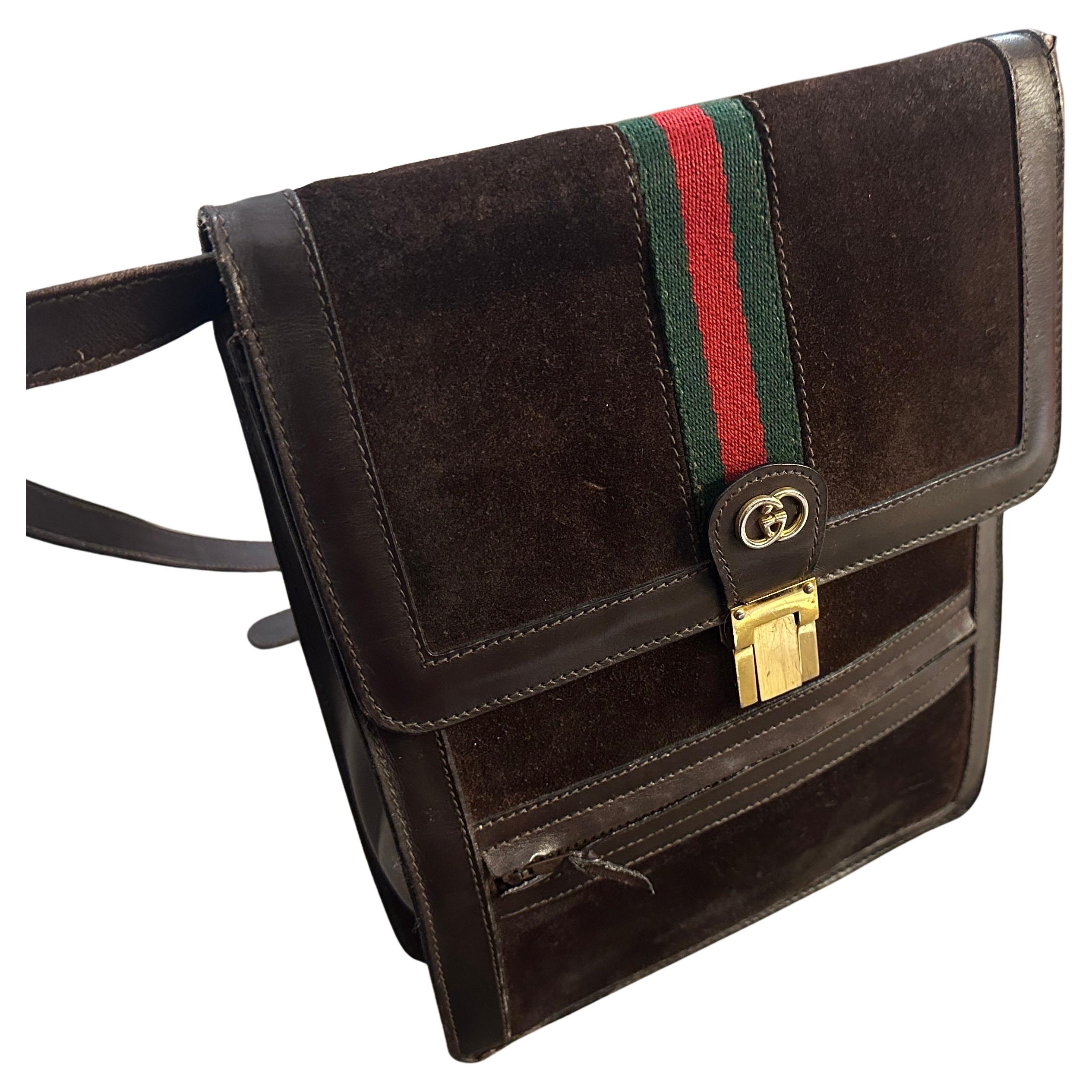 This is a classic 1970s Gucci men's bag, reflecting the timeless sophistication and craftsmanship for which Gucci is renowned. The bag features a vertical rectangular design crafted from rich brown suede with leather accents. Its front flap closure