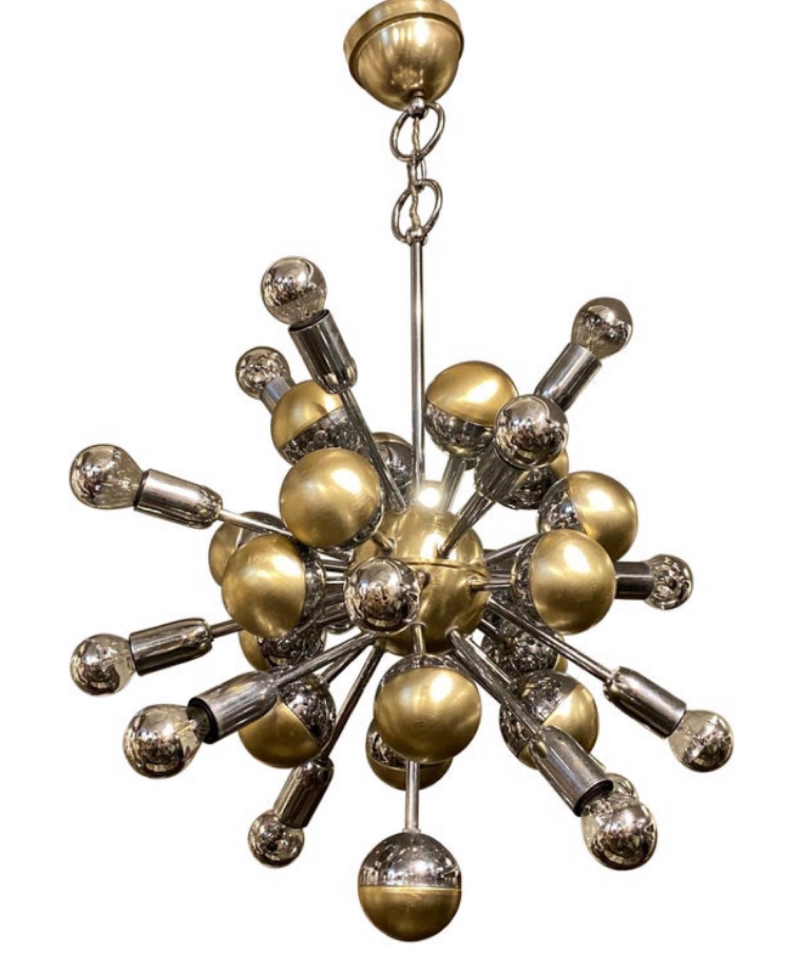 An amazing chromed metal and gilded aluminium sixteen lights sputnik chandelier. It's in good conditions, it works 110-240 volts and needs 16 regular e14 bulbs. It has been designed and manufactured in Italy by Reggiani.
