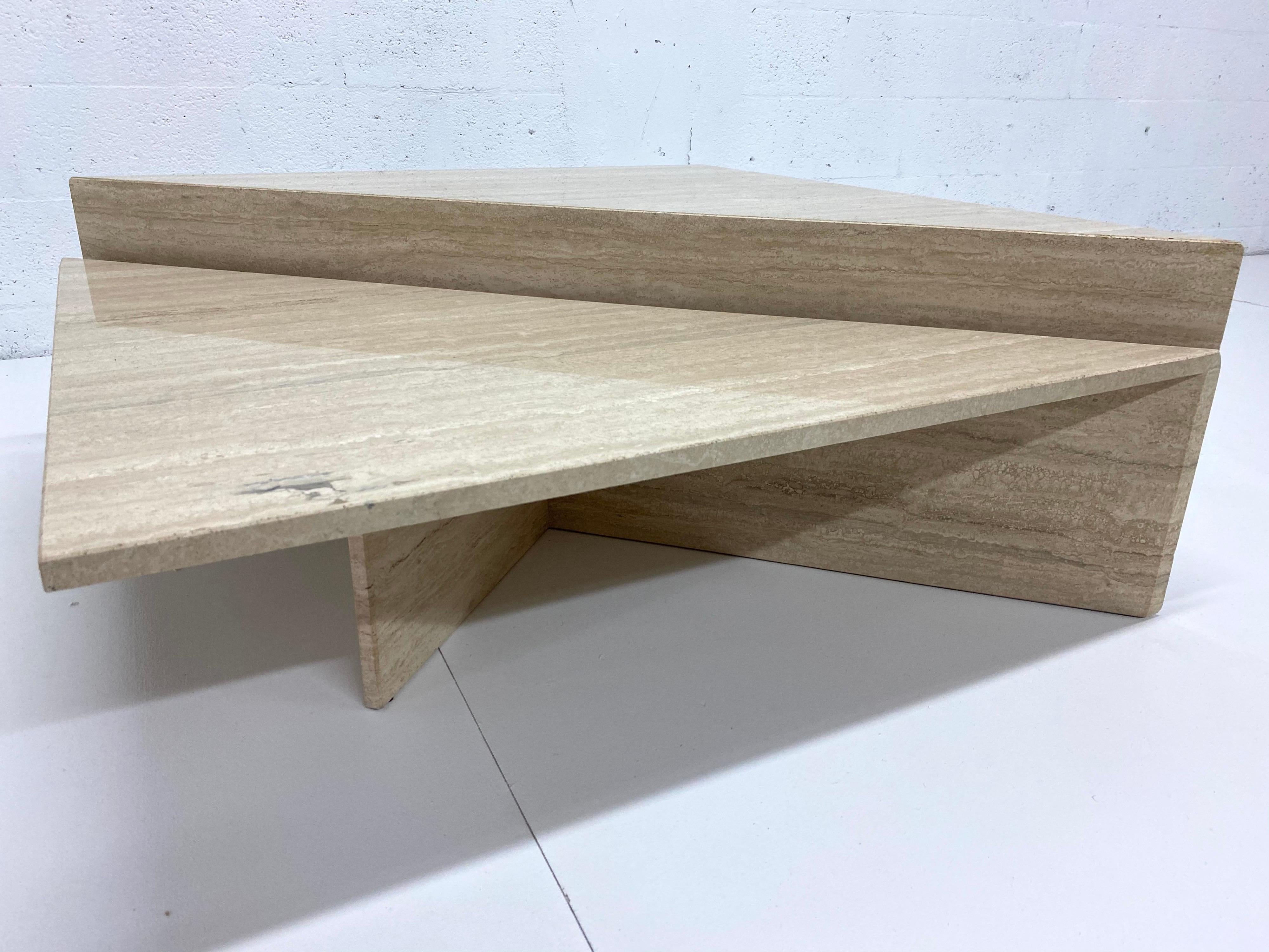 Two piece triangle travertine marble coffee table likely produced by Up & Up, Italy, 1970s.

Measures: Large: W 55.25”, D 27.25”, H 15.5”
Small: W 55.25”, D 27.25”, H 11.5”.
Places together: 39.25” x 39.25”