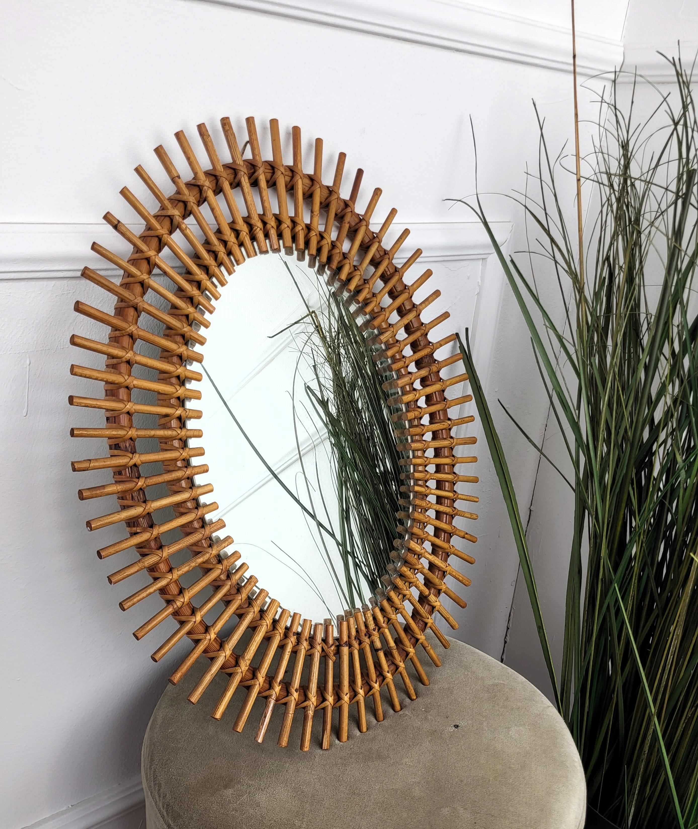 Beautiful 1970s Italian Mid-Century Modern oval shaped wall mirror made of rattan and bamboo. This charming piece is in the typical style of Franco Albini, Adrien Audoux and Vittorio Bonacina where the organic beauty of the woven materials is