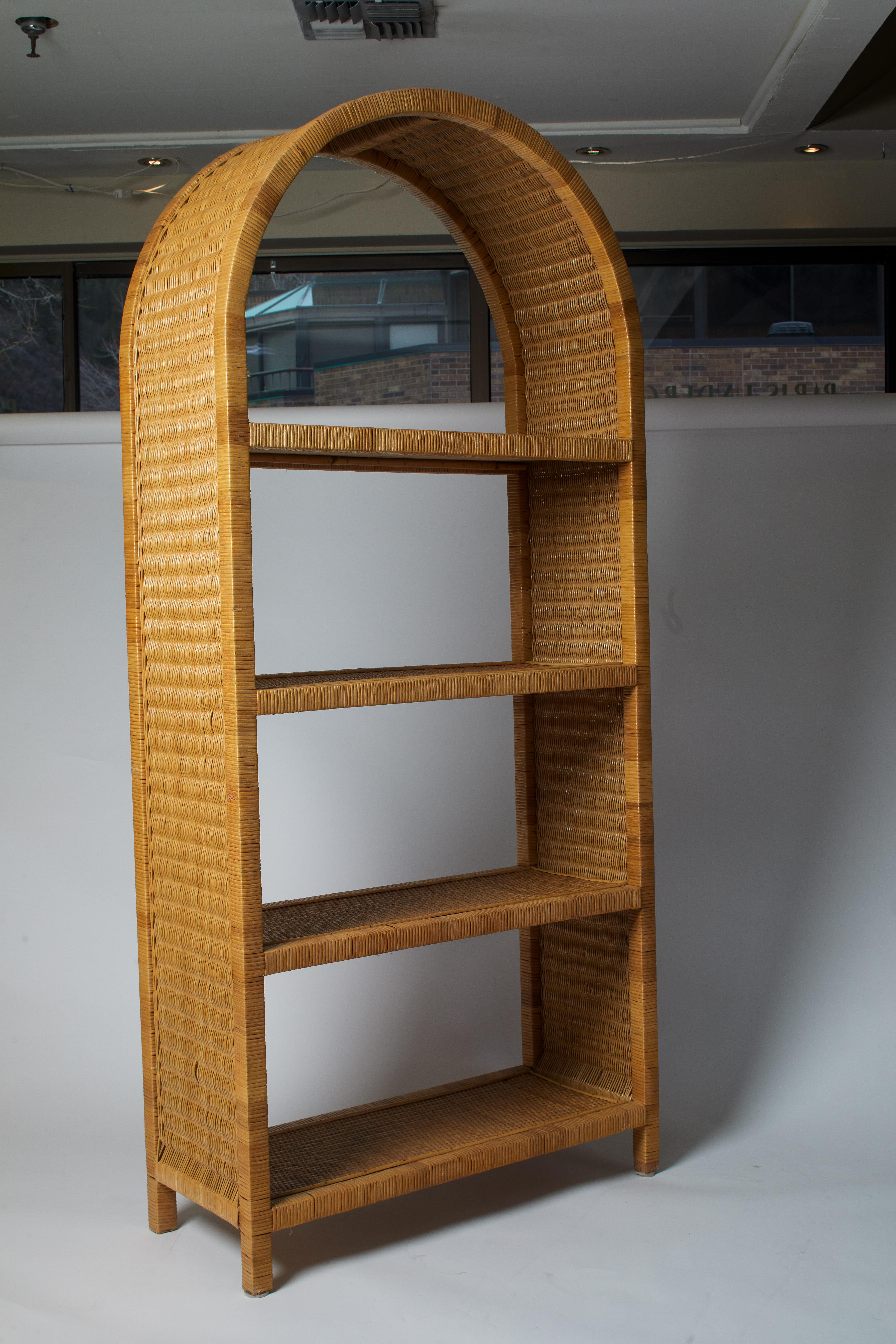 1970s Italian bamboo and wicker curved top etagere with four shelves. The Top shelf is perfect for showcasing a sculpture or objet while the bottom shelves fit vases, plates and more.