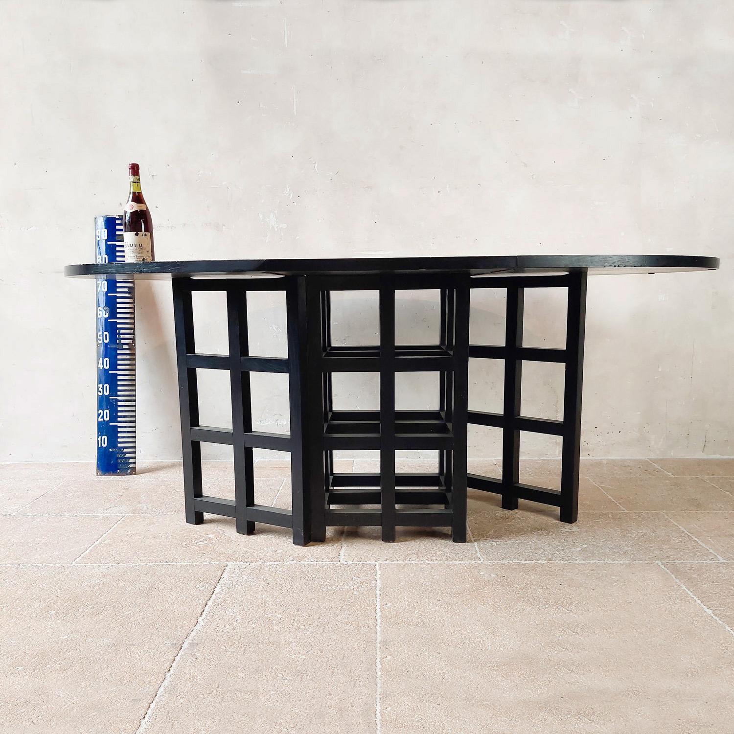 Elegant dining set, designed by Charles Rennie Mackintosh and expertly manufactured in Italy during the 1970s. This set includes a sophisticated oval dining table and four matching chairs.

The oval table features a sleek black ash finish,