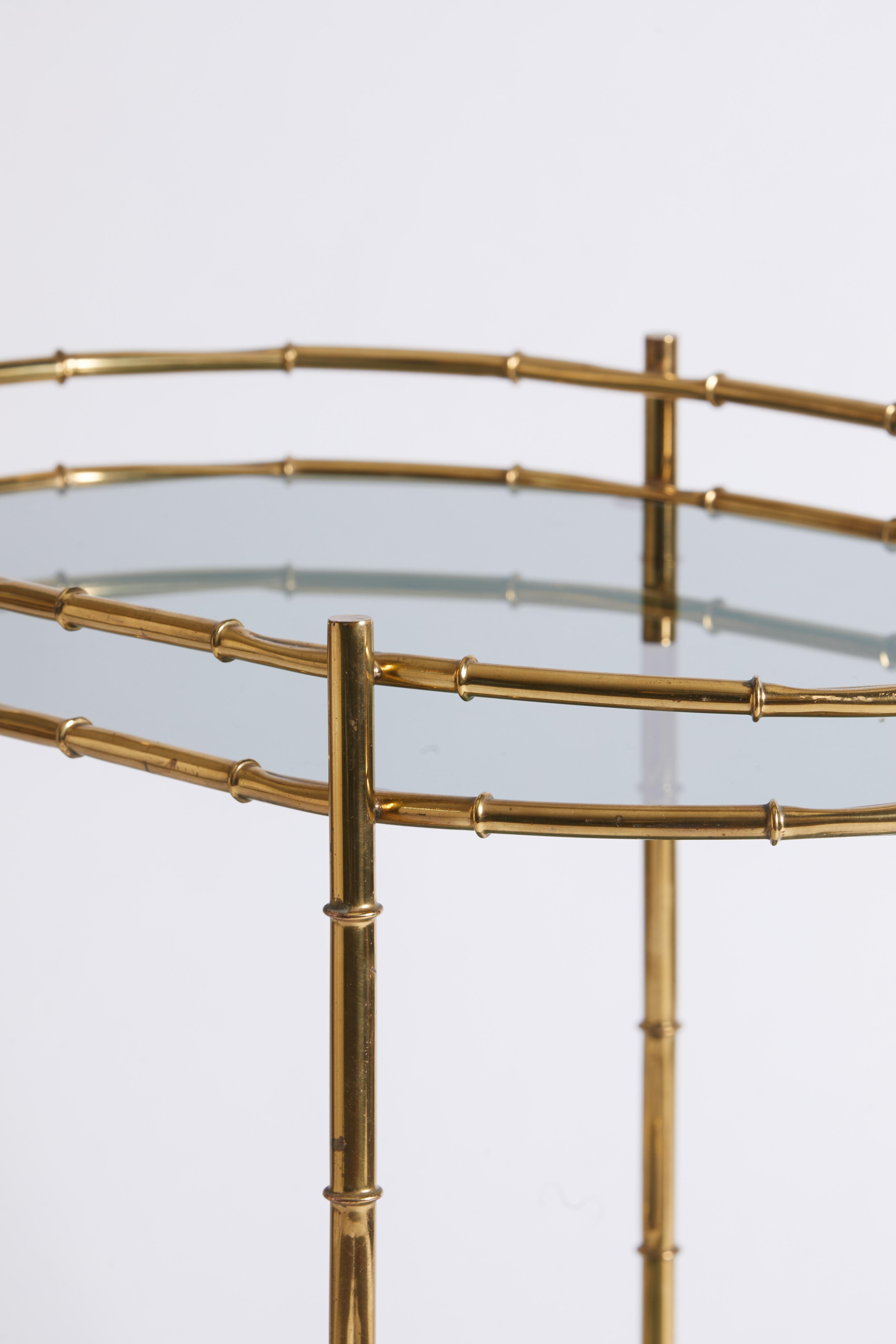 1970s Italian bar cart featuring a faux bamboo design and smoked glass two-tier shelves.