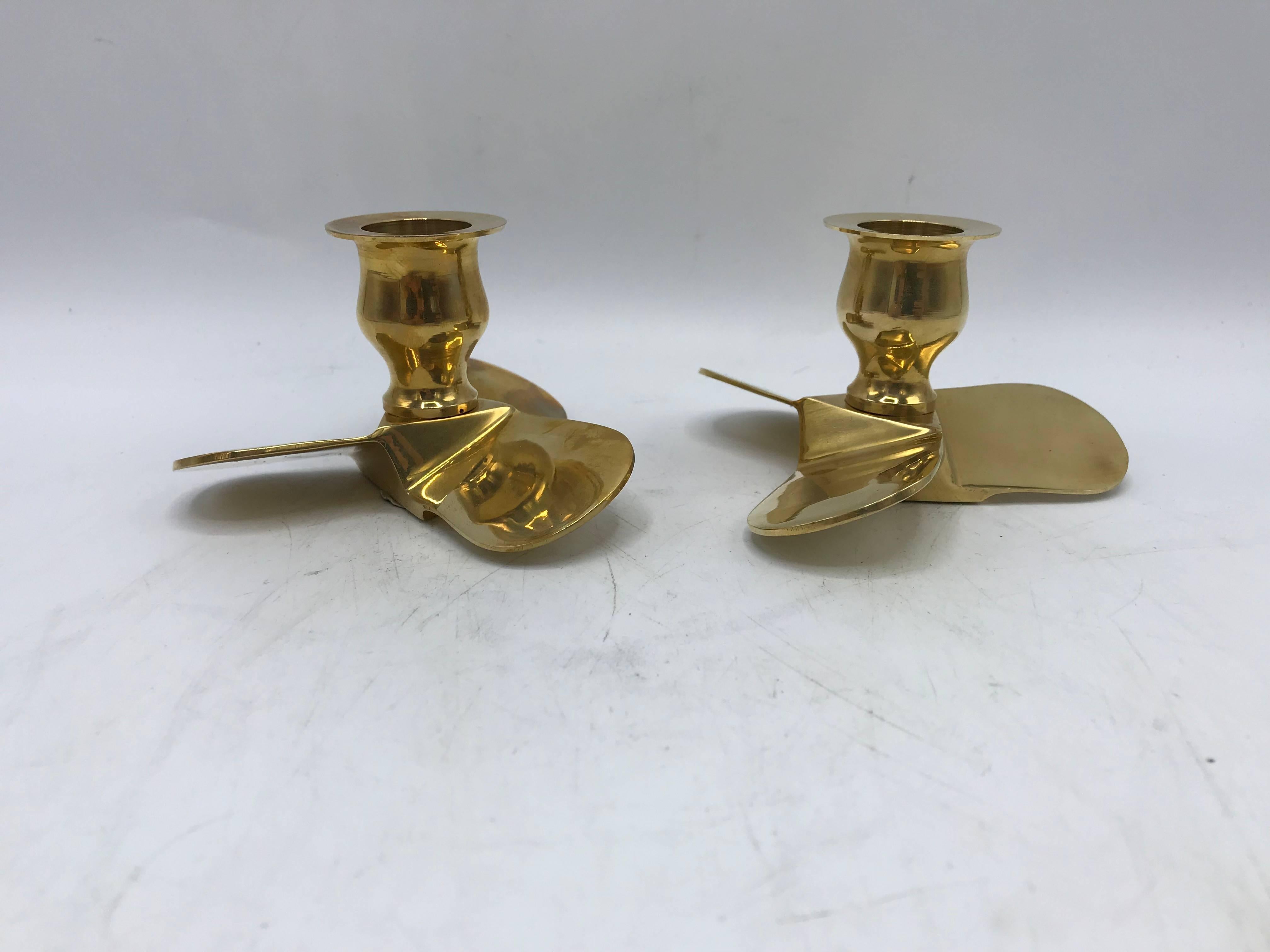 Listed is a stunning, pair of 1970s Italian polished-brass boat propeller candlestick holders. Padded on underside.