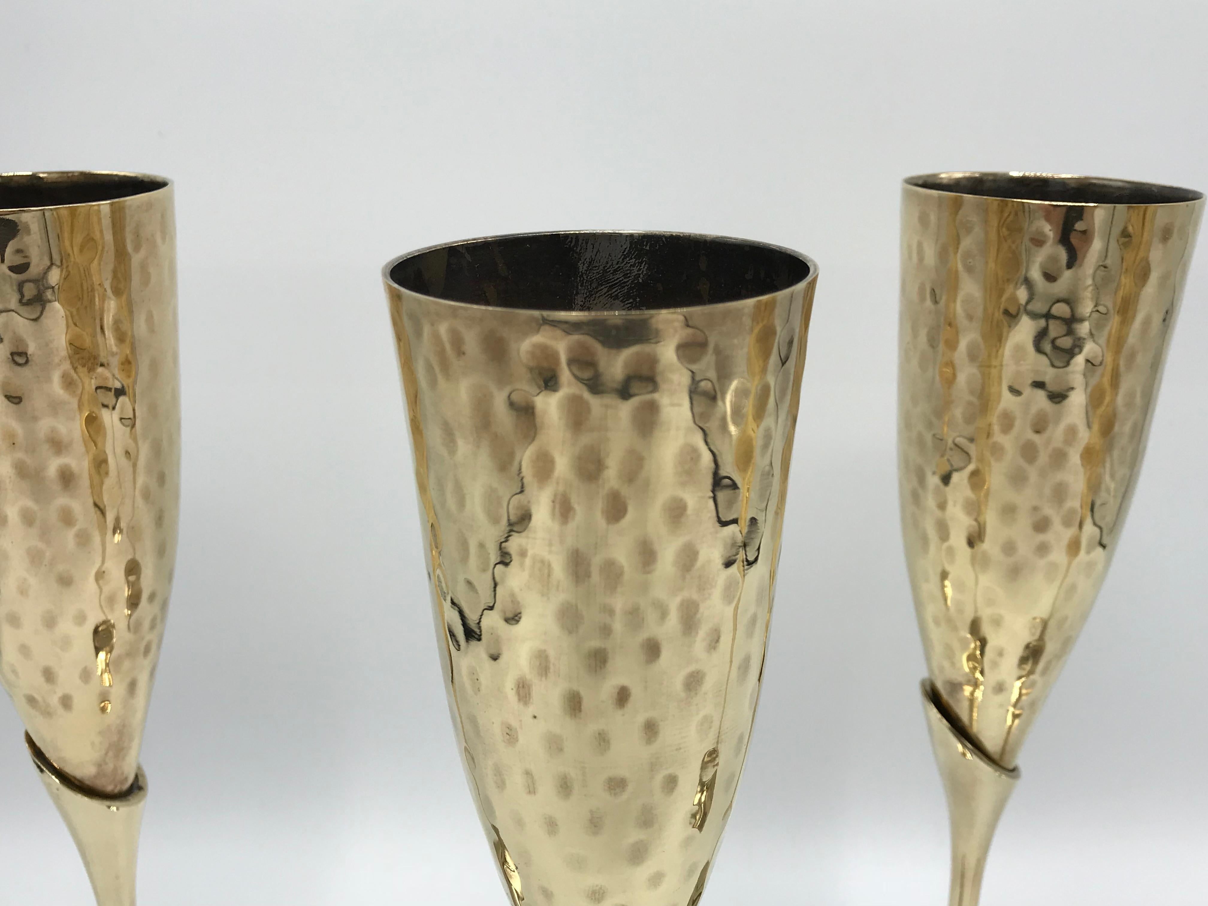 Listed is a fabulous, set of four, 1970s Italian brass champagne flutes with a hammered look. Heavy, weighing nearly 3lbs for the set of four.