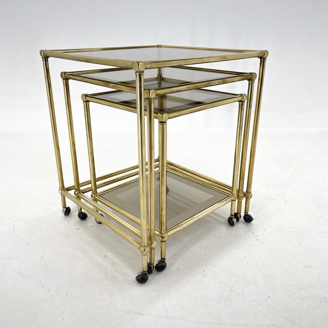 Set of 3 coffee tables made of brass and smokey glass. 
All parts are original in very good vintage condition (see photo). 
Made in Italy in the 1970's.