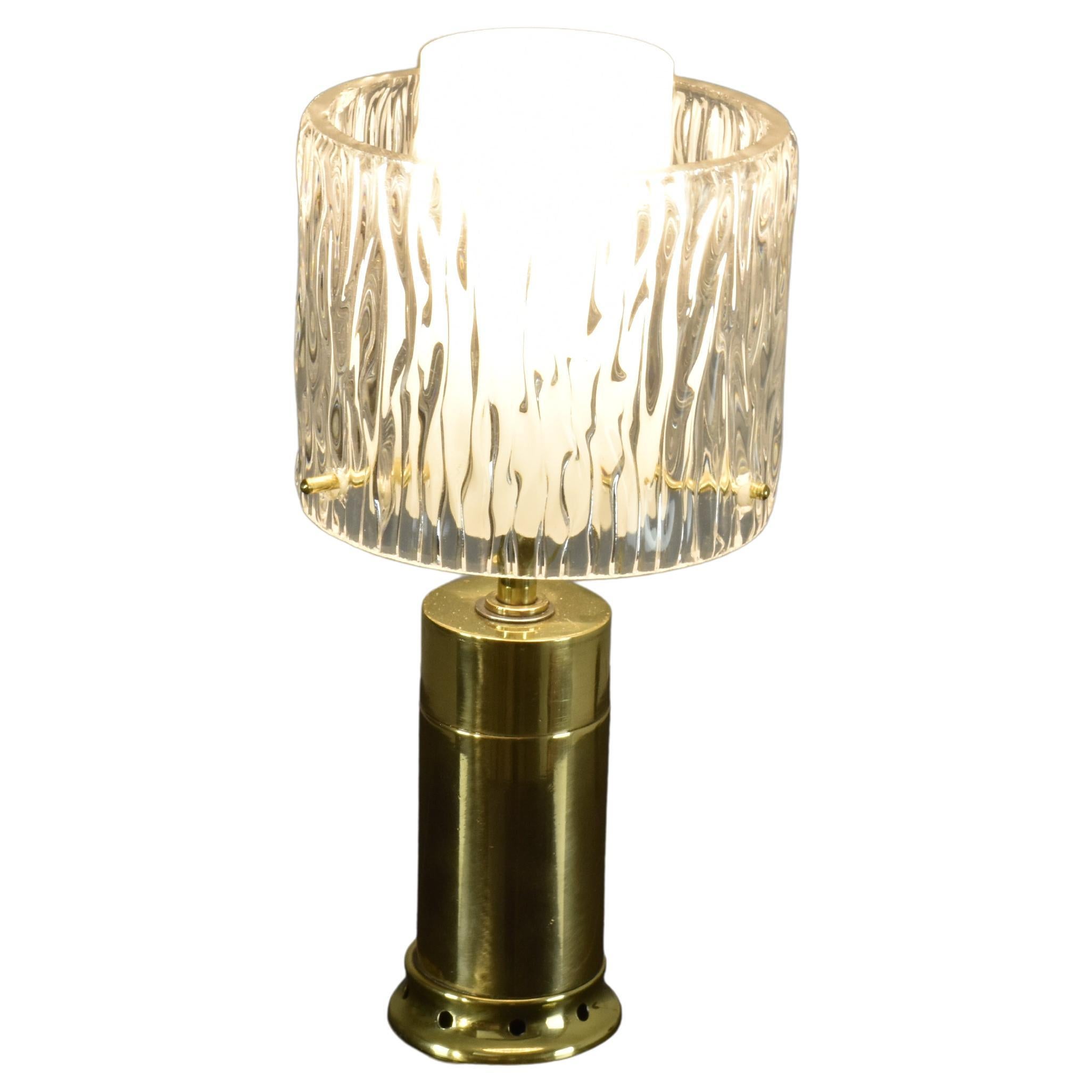 A beautiful funky Italian table lamp from the 1970s designed with a sleek brass base and a double cylinder-shaped shade. The inside shade is taller and in milk glass, and the outside glass shade is in beautiful textured glass. A sophisticated brass