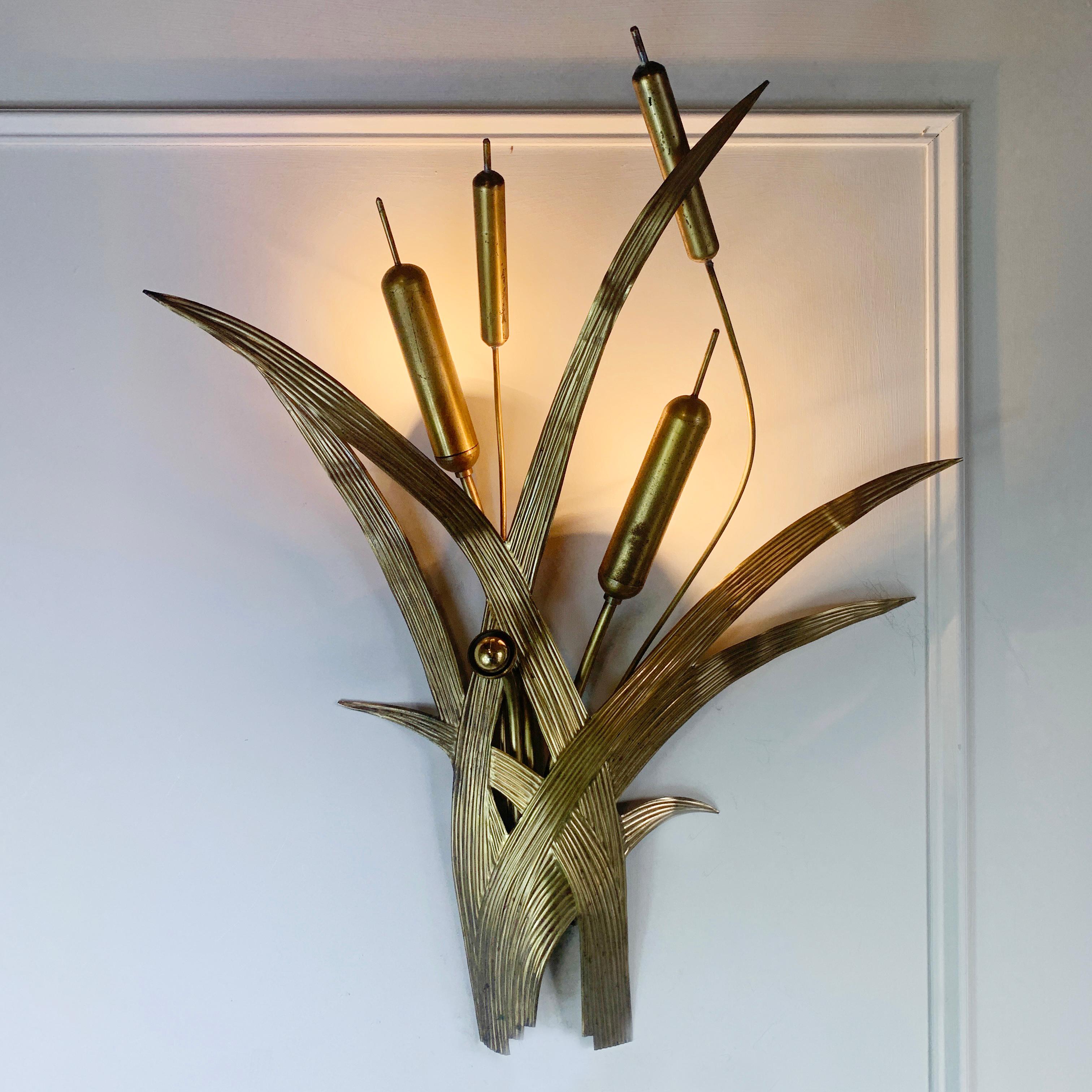 A 1970's Italian wall light, the formed broad brass textured leaves create the body of the light, with four bulrush stems to the top, inside two of the bulrush heads are the hidden bulb holders.

This is a beautifully designed light that gives a
