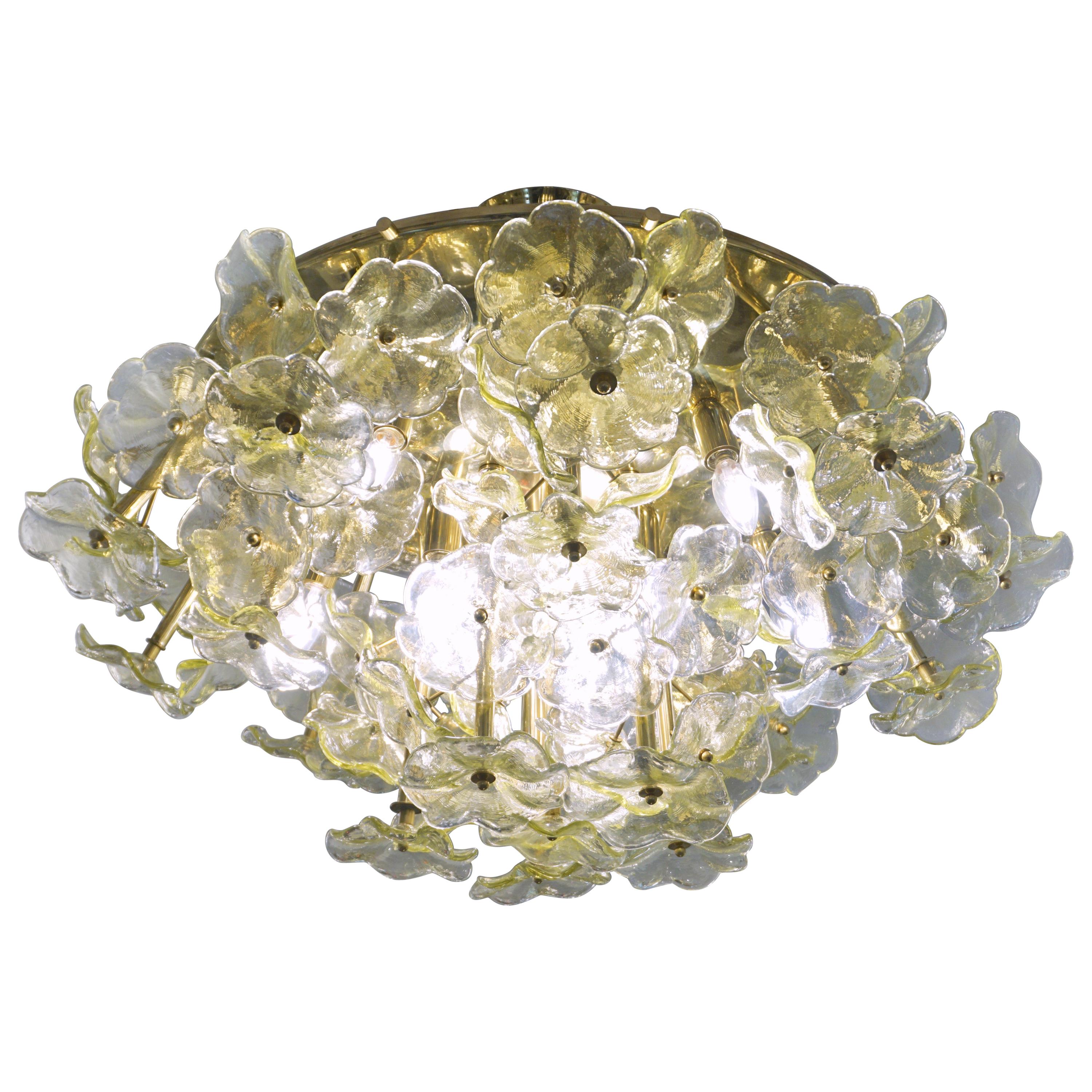 1970s Italian one-of-a-kind amber yellow Murano glass flower chandelier, organic modern design entirely handcrafted in Italy, the round convex structure in brass that can be mounted nearly flush is artistically and uniquely decorated with a cluster