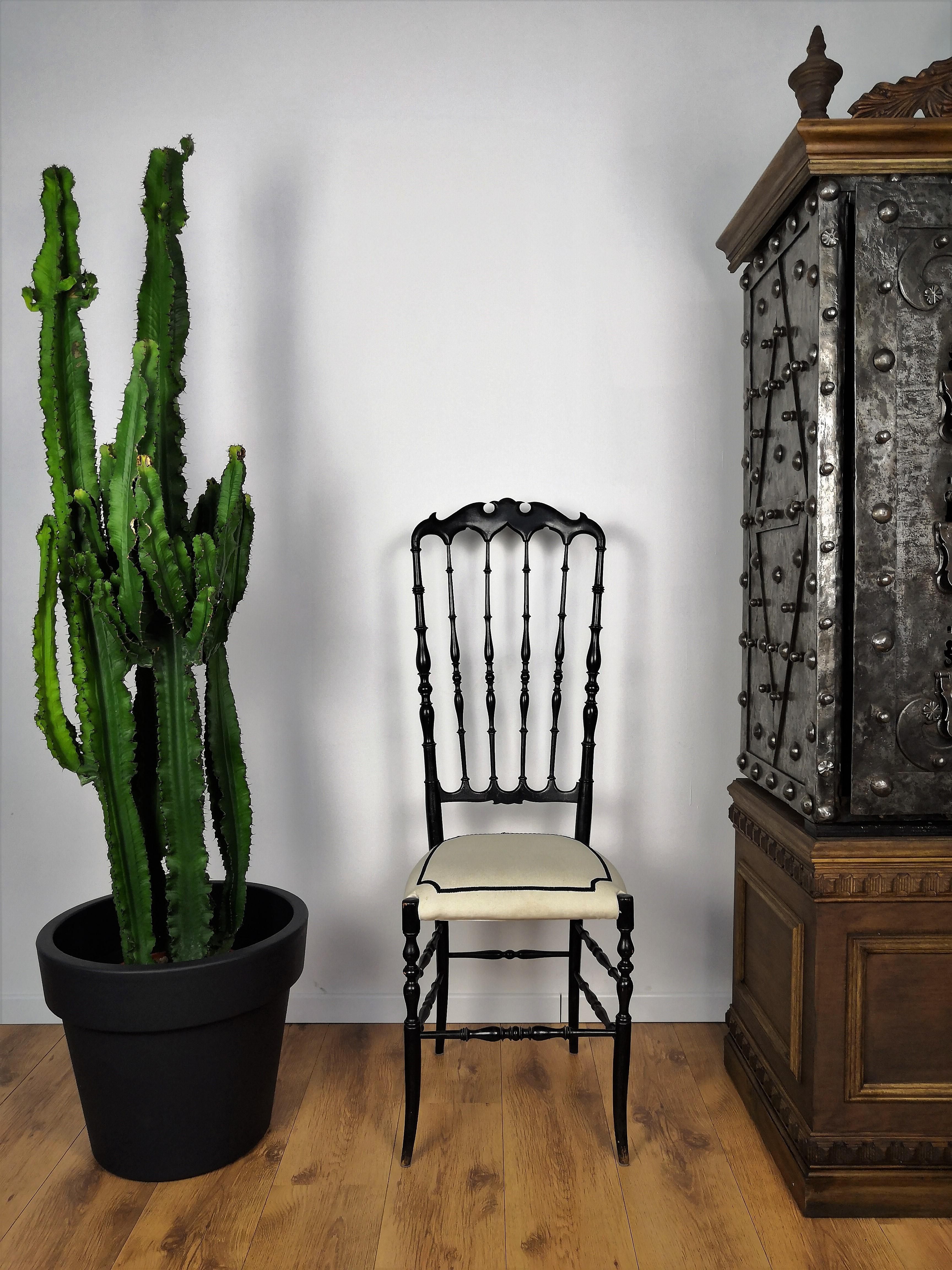 1970s Italian Chiavari chair in black carved wood and tall back, 118 cm 46,4 inches, with great shiny vintage patina and perfect long lasting solid structure. The actual upholstery is in typical contemporary modern black and white linear style and