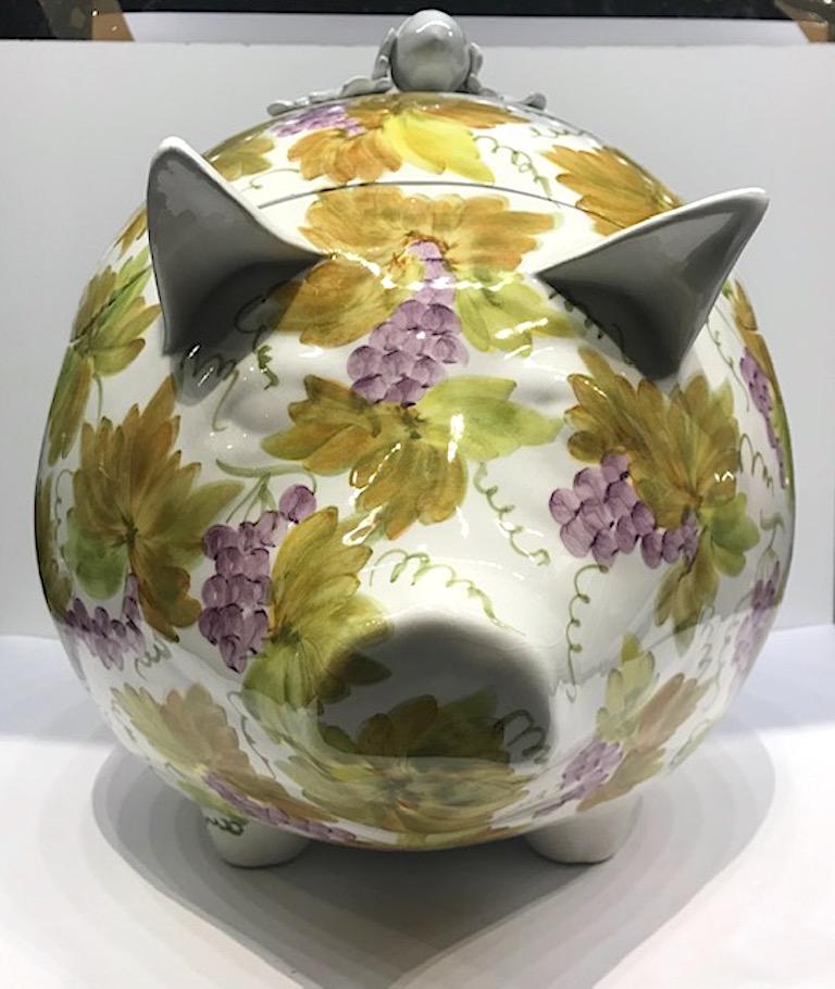 A lovely decorative Italian hand painted ceramic pig tureen made in the town of Este in the province of Padova. Circa 1970. Hand painted with a design of grape bunches and grape leaves in purples, greens and earthy golds. The top lid has a hand made