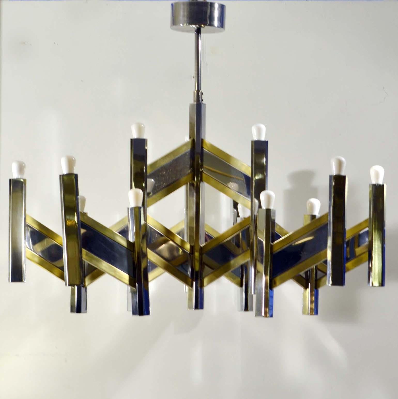 Largest scale sculptural mid century chandelier by the Italian designer Gaetano Sciolari for Lightolier, circa 1970, made in high quality polished brass and chrome mix creating a mirror surface. It consists of a center hexagonal column from which 3