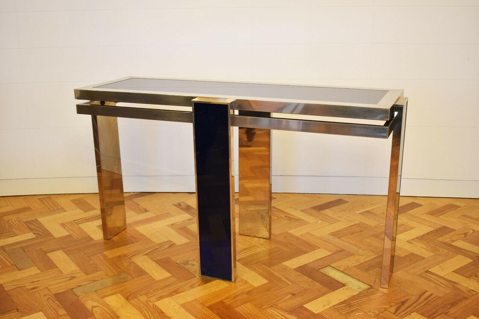 Rare and unique, this console table features a glass top that is set within a chrome base, that boasts a navy Perspex detailing. 

This spectacular Mid-Century Modern design piece was made by the renowned designer, Giacomo Sinopoli for Liwans, the