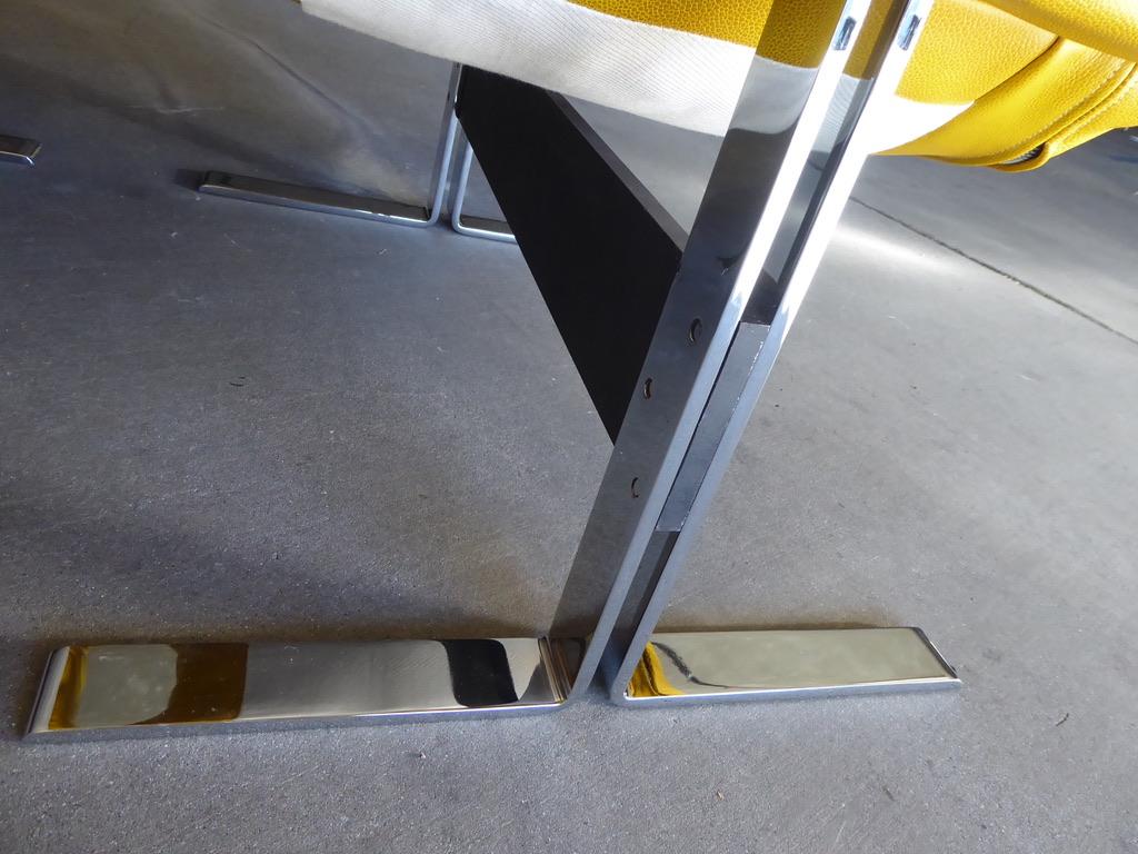 A 1970s chrome-plated solid flat-bar steel Italian lounge chair and ottoman. The heavy steel frame has been recently re-plated and the high-quality yellow leather is a recent addition. The dimensions in the listing are for the chair. The dimensions