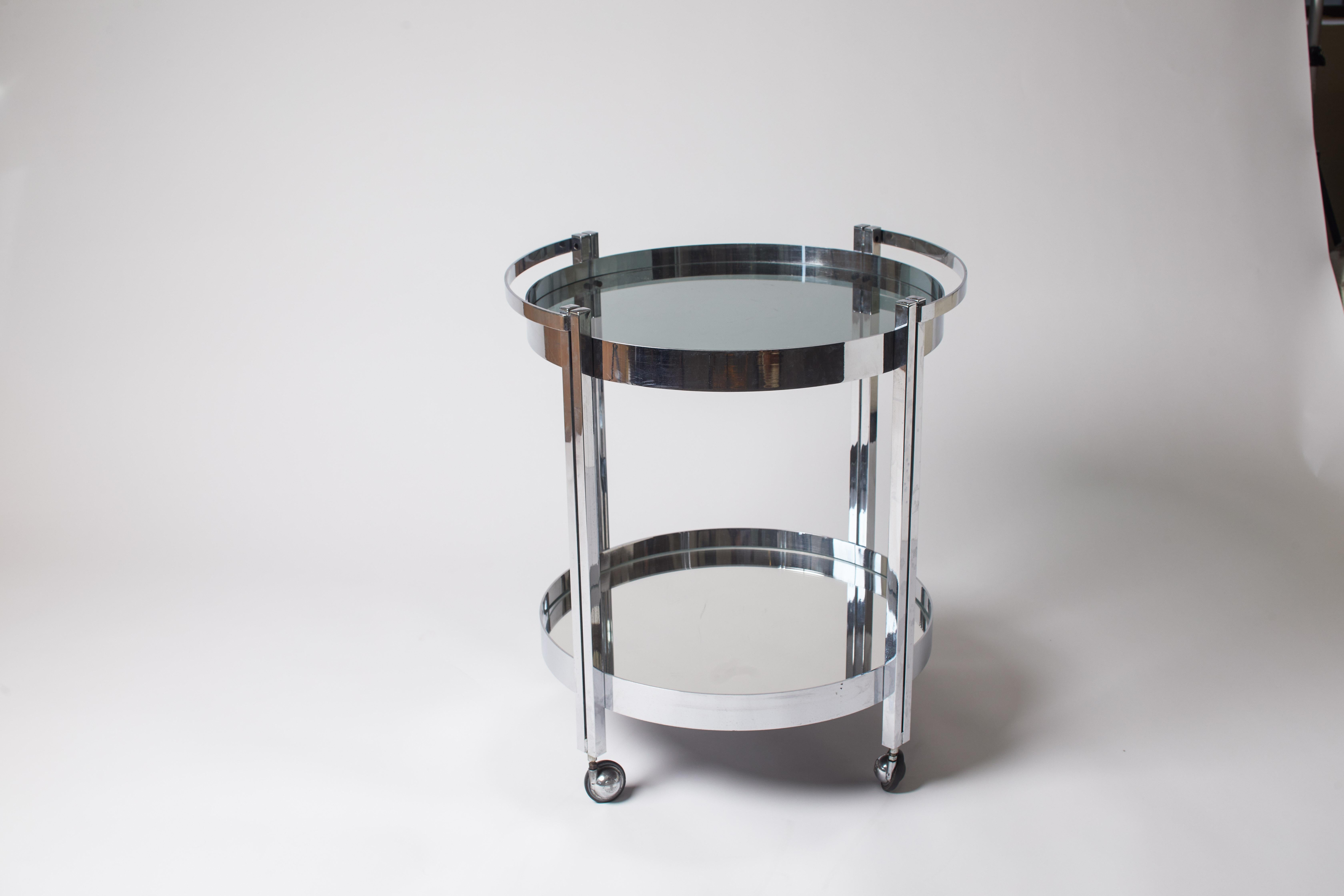 1970s Italian chrome two-tier circular bar cart with glass top and mirrored bottom shelf.