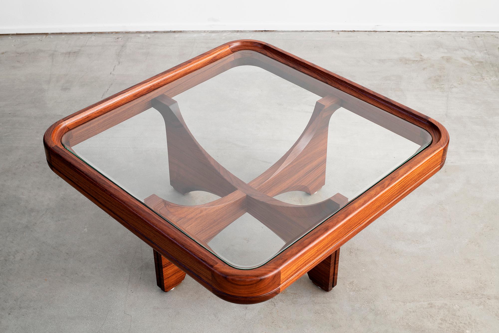 Beautiful Italian glass and walnut coffee table with curved corners and floating sculptural legs. 
 